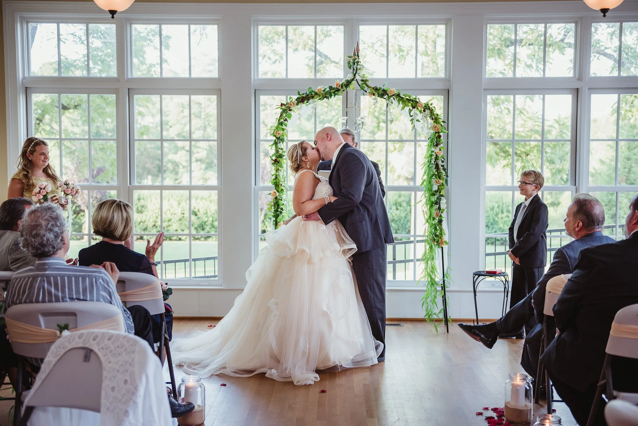 The bride and groom have their first kiss as a married couple at their wedding at the Rand-Bryan House in Raleigh, photos by Rose Trail Images.