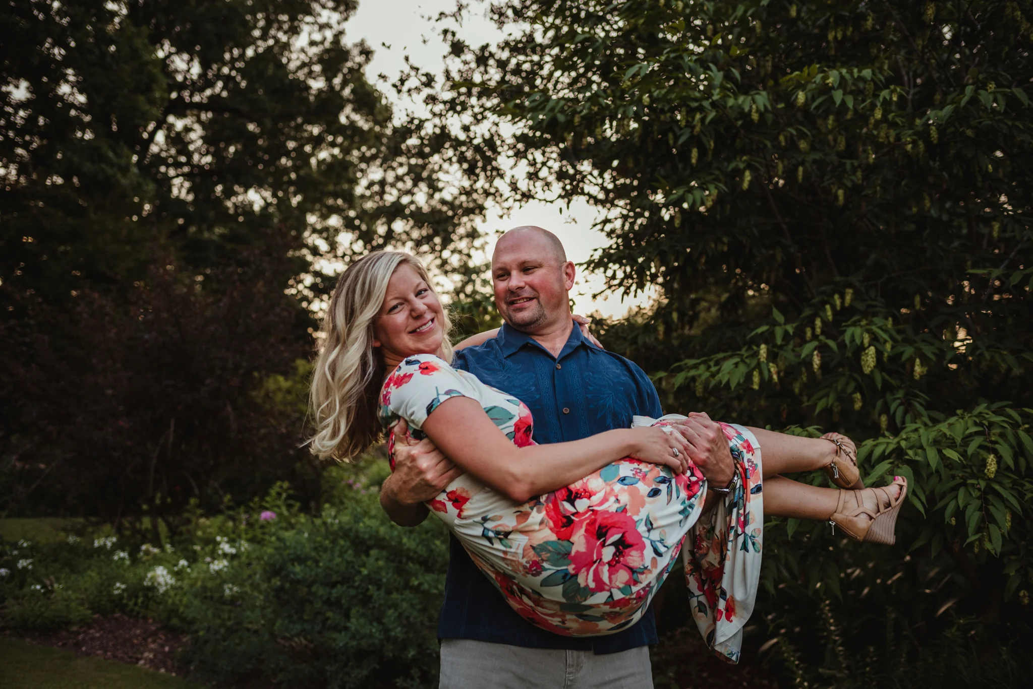 The groom picks up his bride during their engagement session at Fred Fletcher Park in Raleigh, North Carolina with Rose Trail Images.