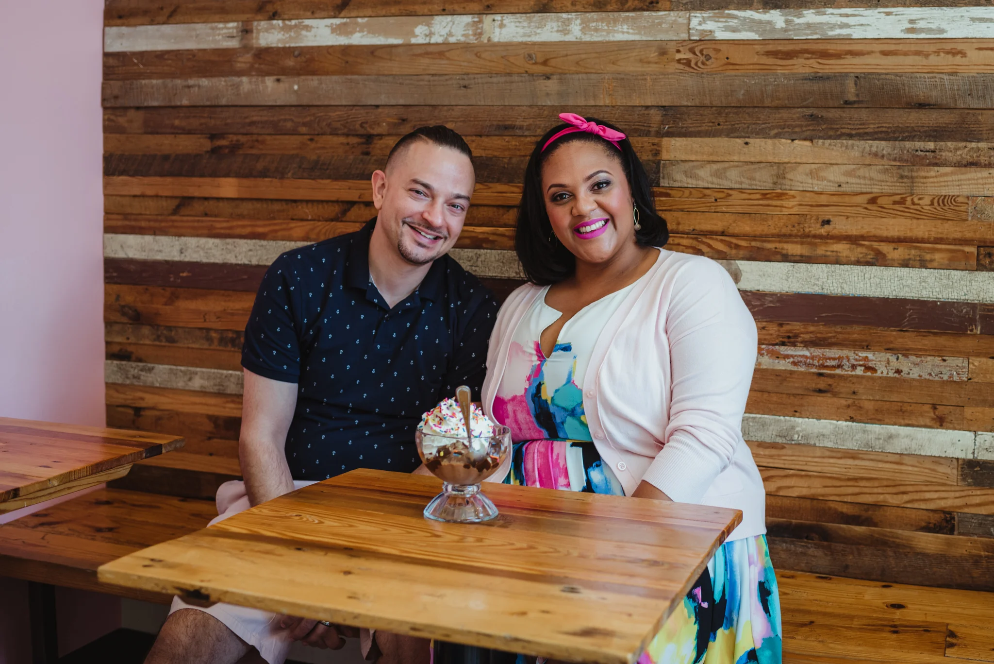 The parents to be sit at The Parlour in Durham during their baby announcement photo session with Rose Trail Images.