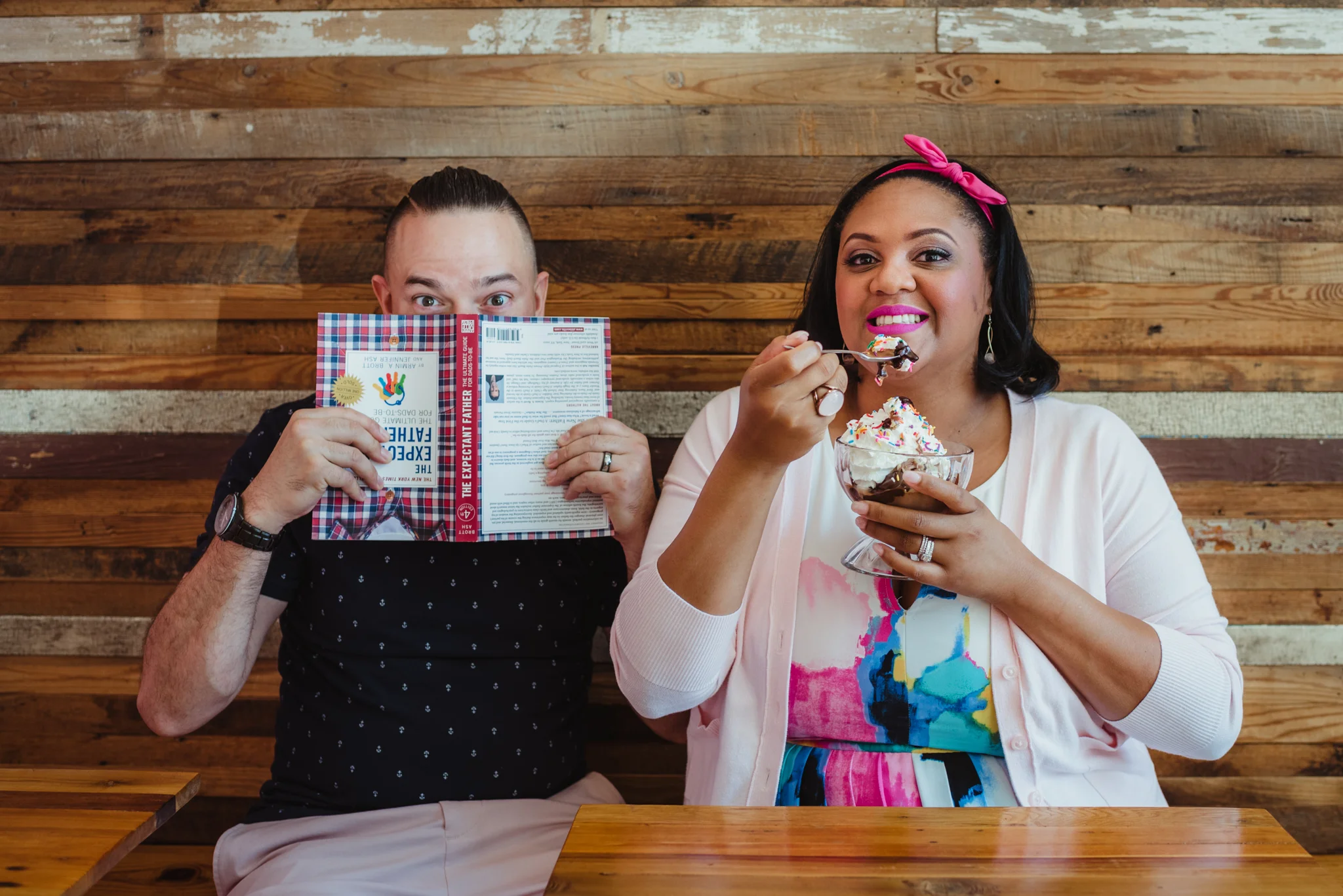 The parents to be sit at The Parlour in Durham and eat ice cream during their baby announcement photo session with Rose Trail Images.