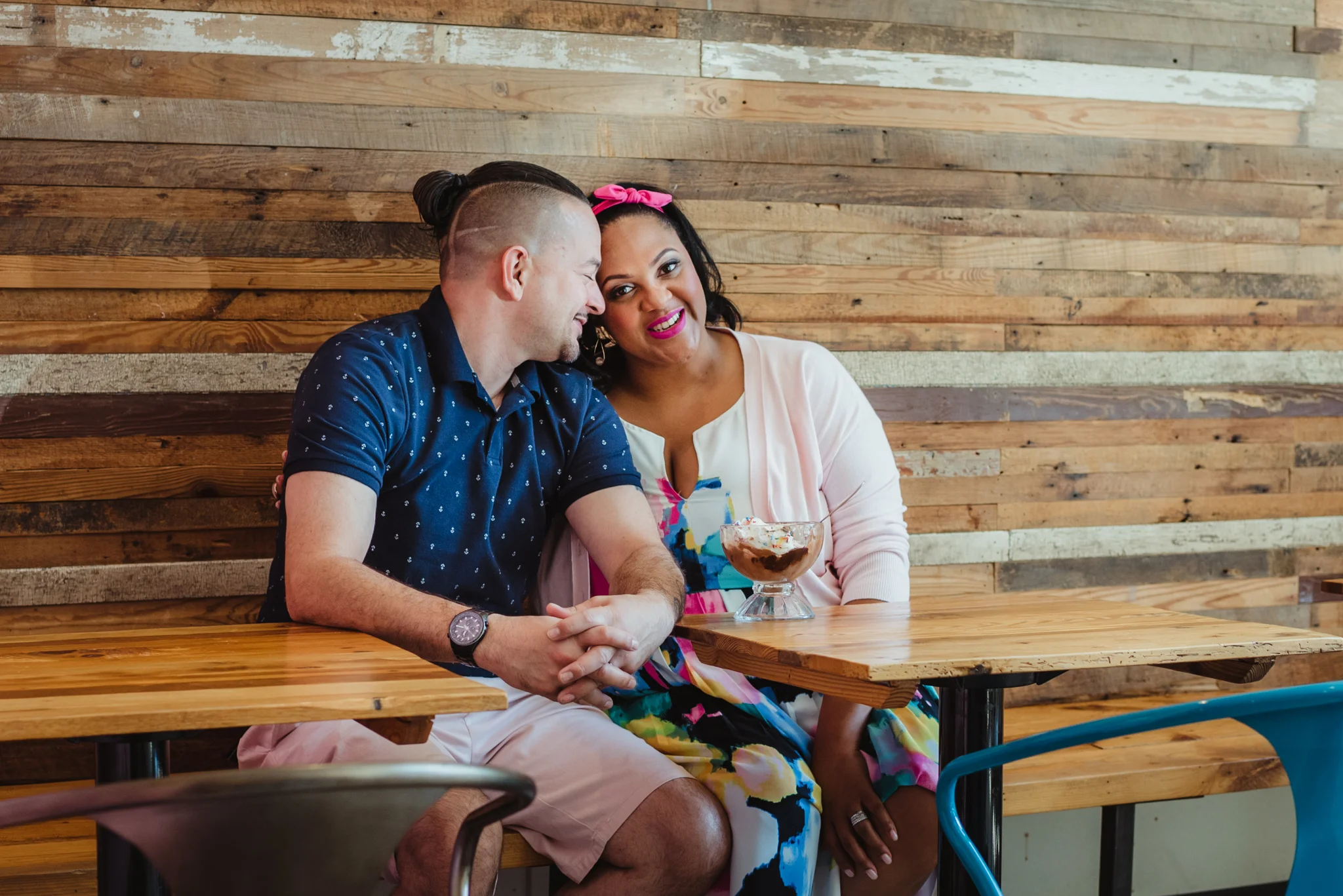 The parents to be cuddle together at The Parlour in Durham during their baby announcement photo session with Rose Trail Images.
