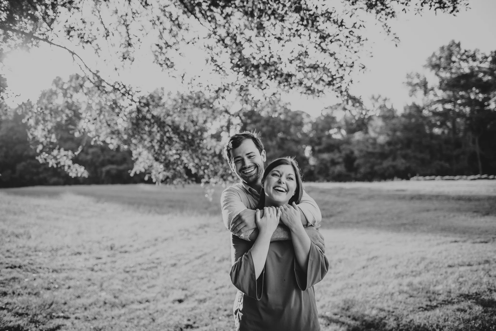 The bride and groom to be laugh together for their engagement pictures with Rose Trail Images at their family farm in Benson, North Carolina.