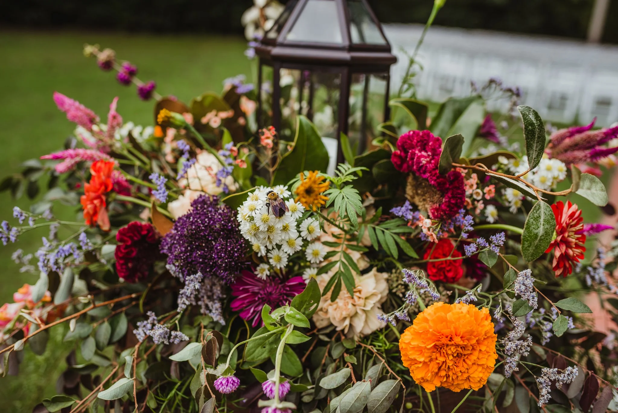 A bumble bee sits in the flowers at the ceremony site before the wedding ceremony at Cedar Grove Acres near North Carolina, photo by Rose Trail Images.