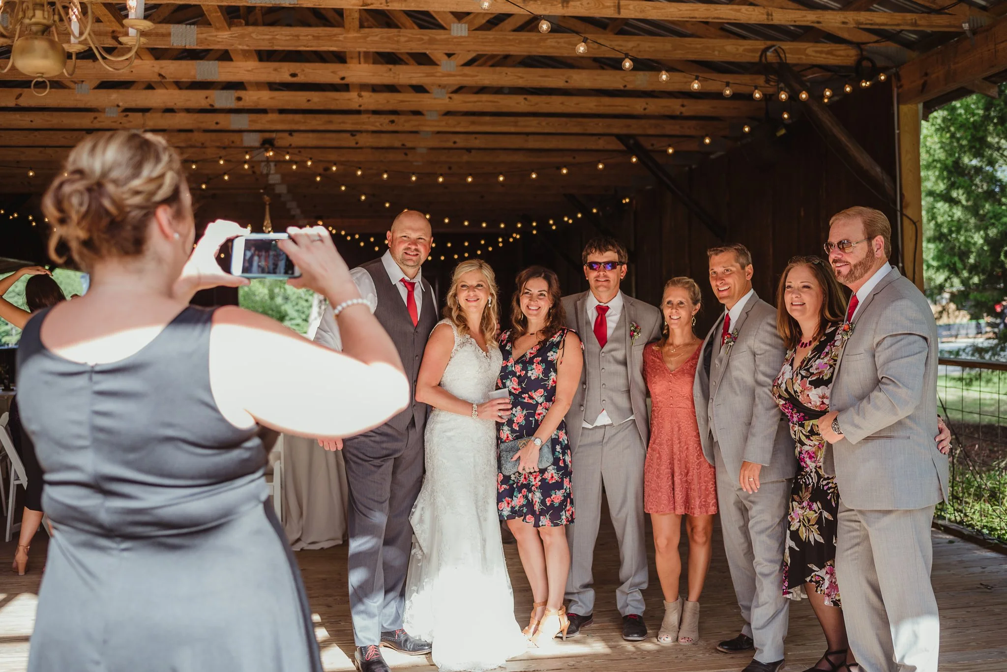 The bride and groom share a picture with friends during their wedding reception at Cedar Grove Acres near Raleigh, pictures by Rose Trail Images.