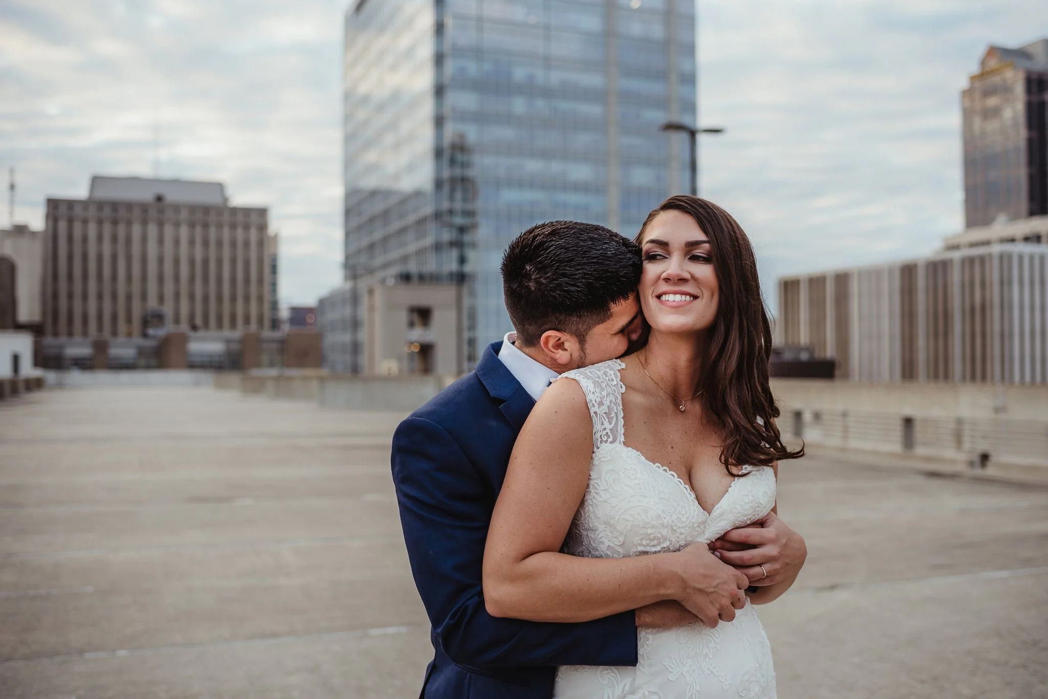 The bride and groom hugged on a rooftop after their wedding ceremony in downtown Raleigh, photos by Rose Trail Images.