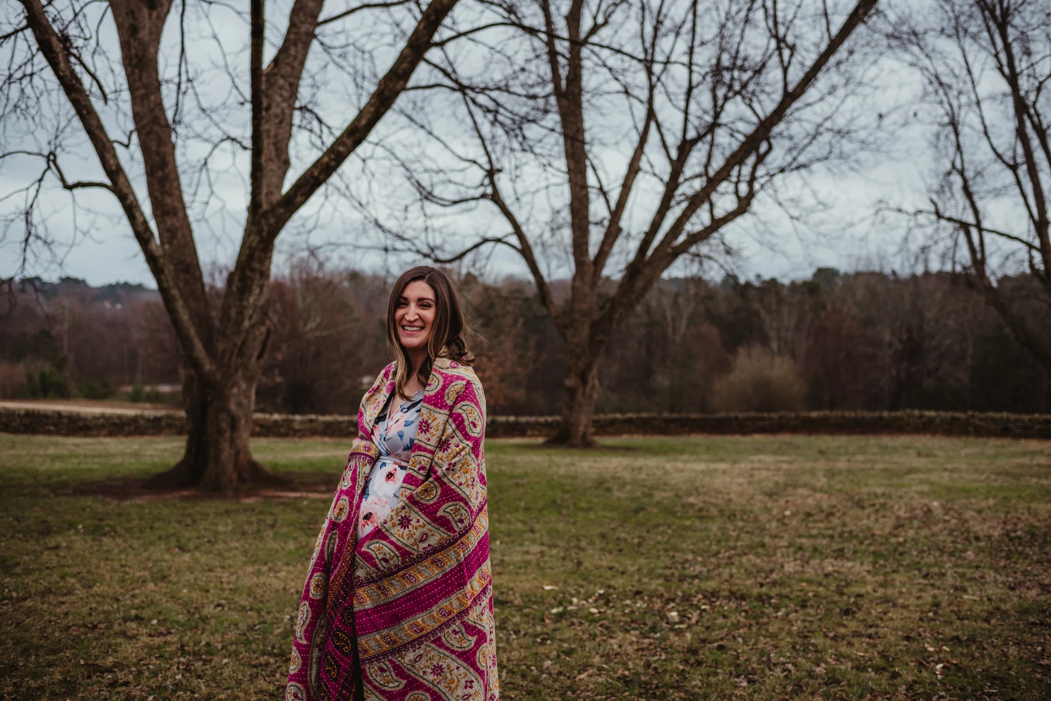 The Mama to be shows off her baby bump under a pink blanket, picture taken by Rose Trail Images at Joyner Park in Wake Forest, NC.