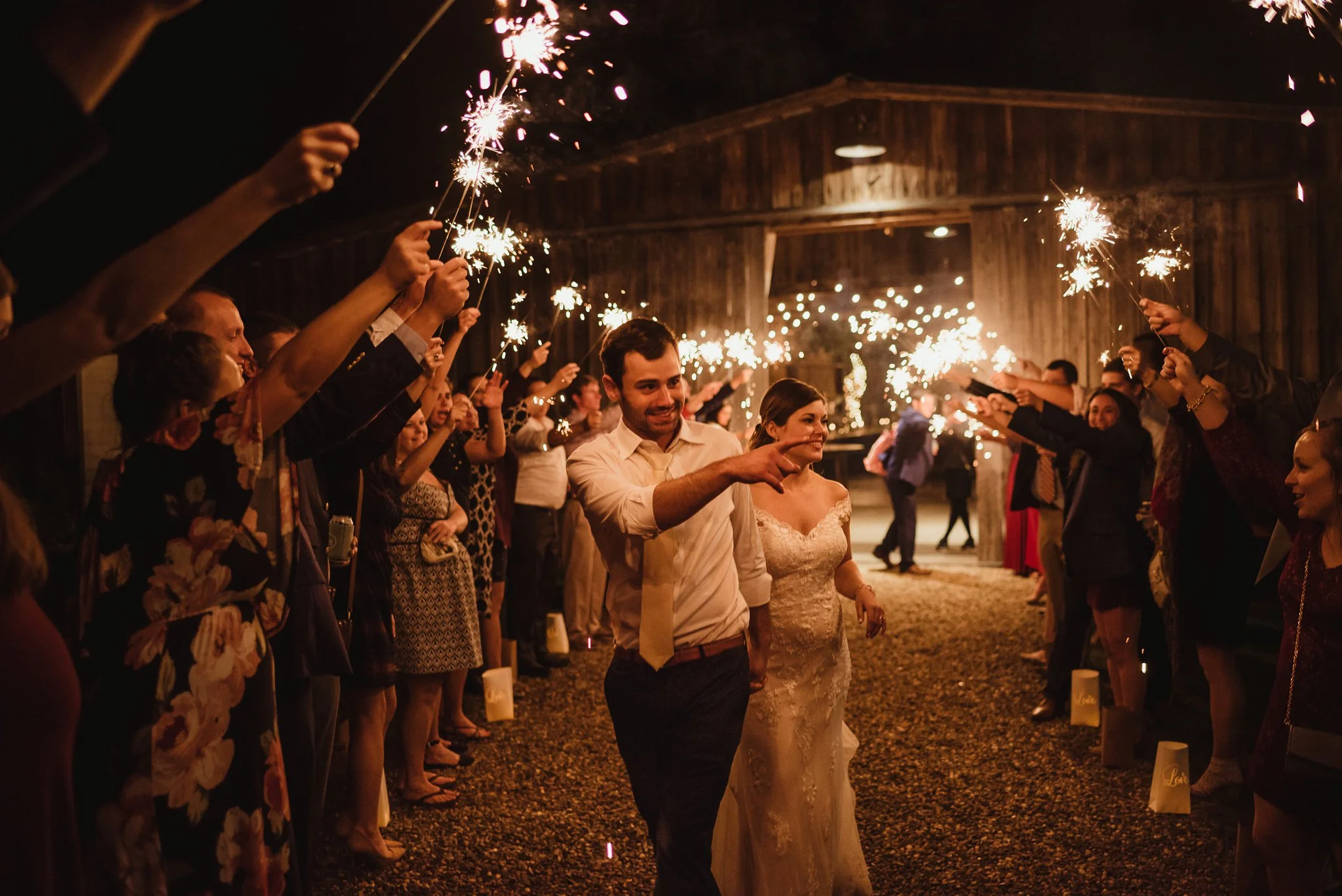 The bride and groom walk off happy during their sparkler send off after their wedding reception at the Little Herb House in Raleigh, North Carolina. Photos by Rose Trail Images.