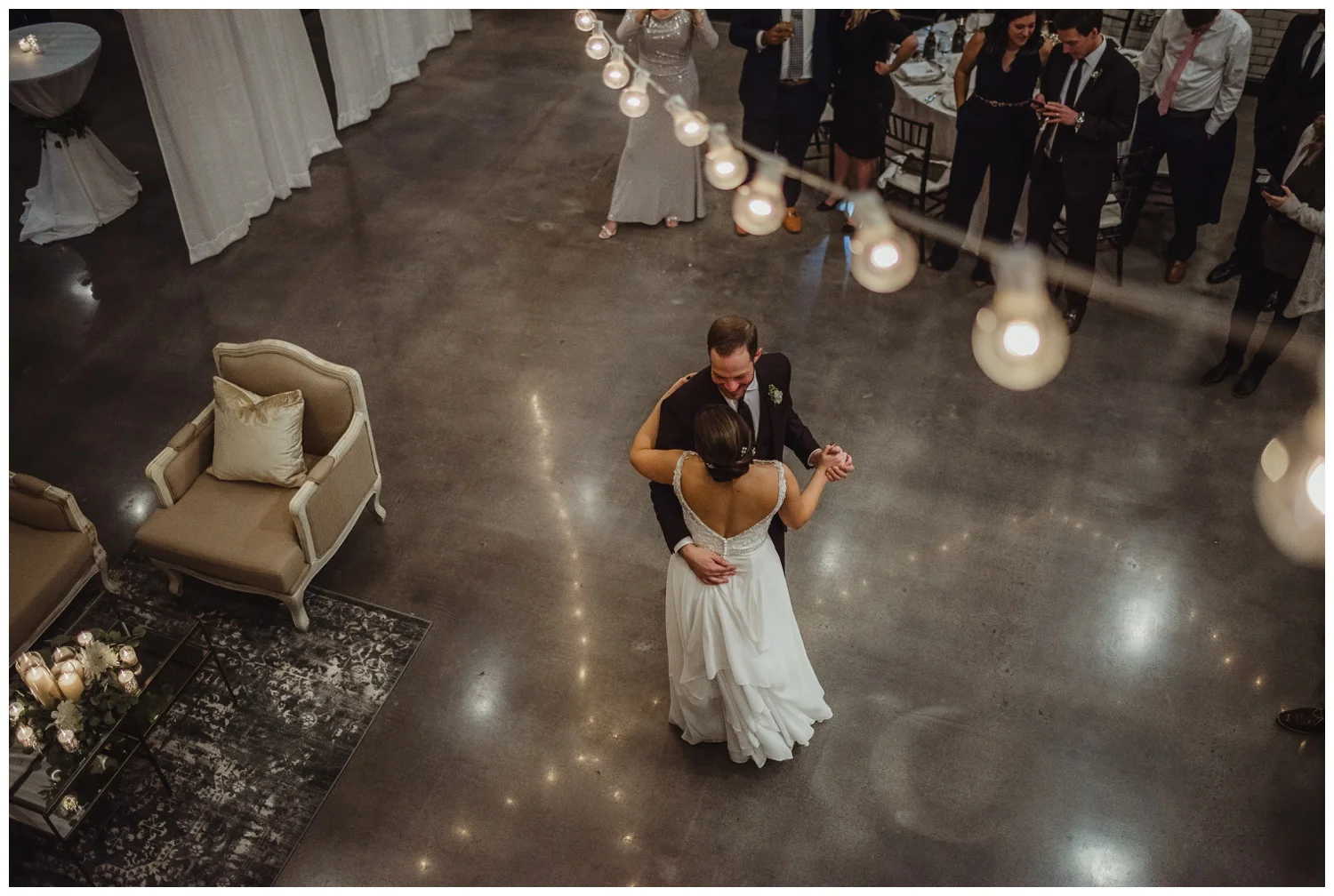 The bride and groom dance their first dance under the market lights in downtown Raleigh, photos by Rose Trail Images.