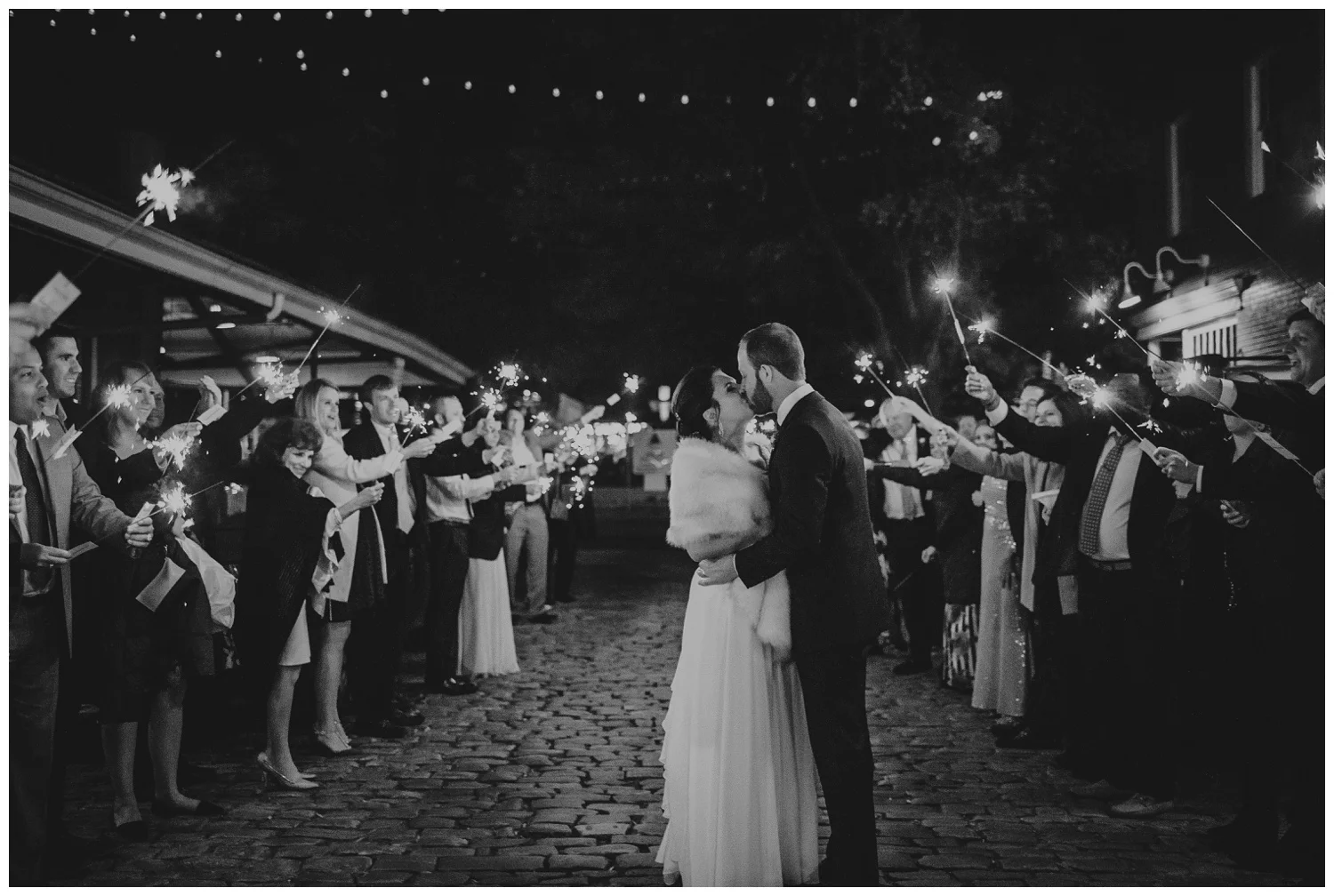 The bride and groom kissed under the sparklers for their exits their wedding reception in downtown Raleigh, photos by Rose Trail Images.