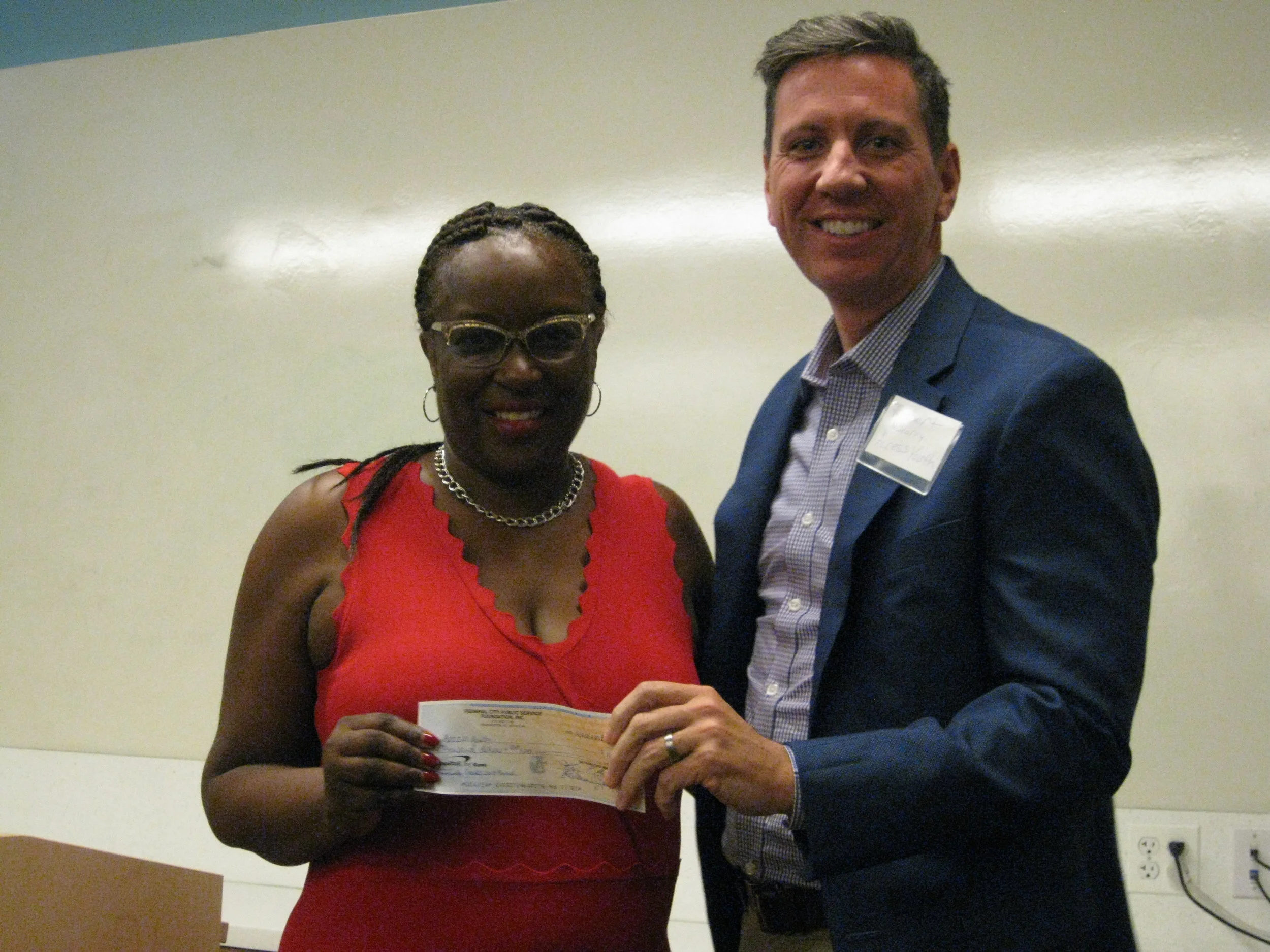 Kay Henley, Chairperson Federal City Public Service Foundation (FCPSF) presenting the 2018, $10,000 Community Grant check to Access Youth, Board of Directors' Treasurer Robert McVearry, Executive Creative Director, O2 Lab, Inc.
