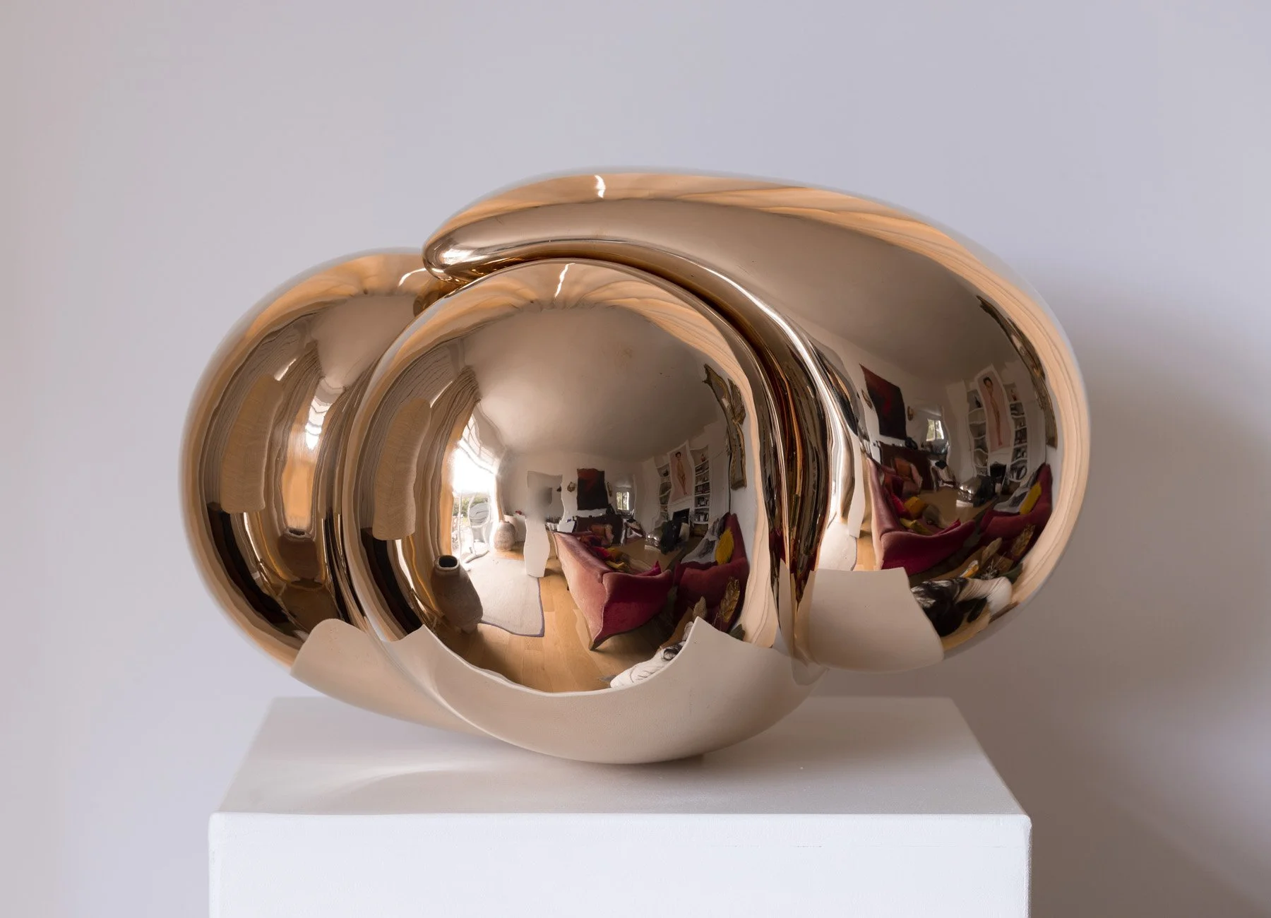 Cœur sculpté par Cat Sirot, série Loving Hearts, finition or rose poli miroir, présenté sur socle blanc