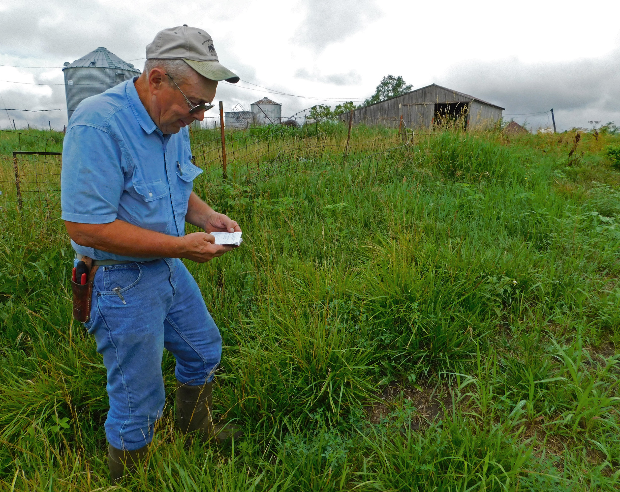 Paul Ackley consults his notebook for notes he took on local weather patterns.