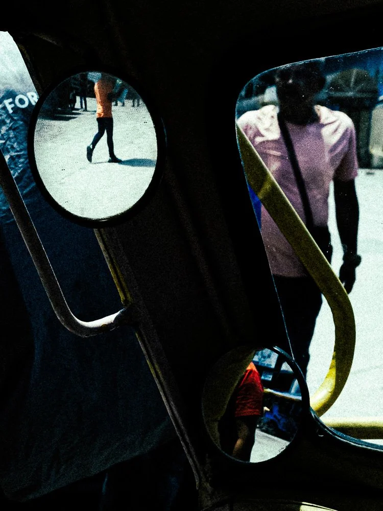 Street scene reflected in the round and side mirrors of a vehicle