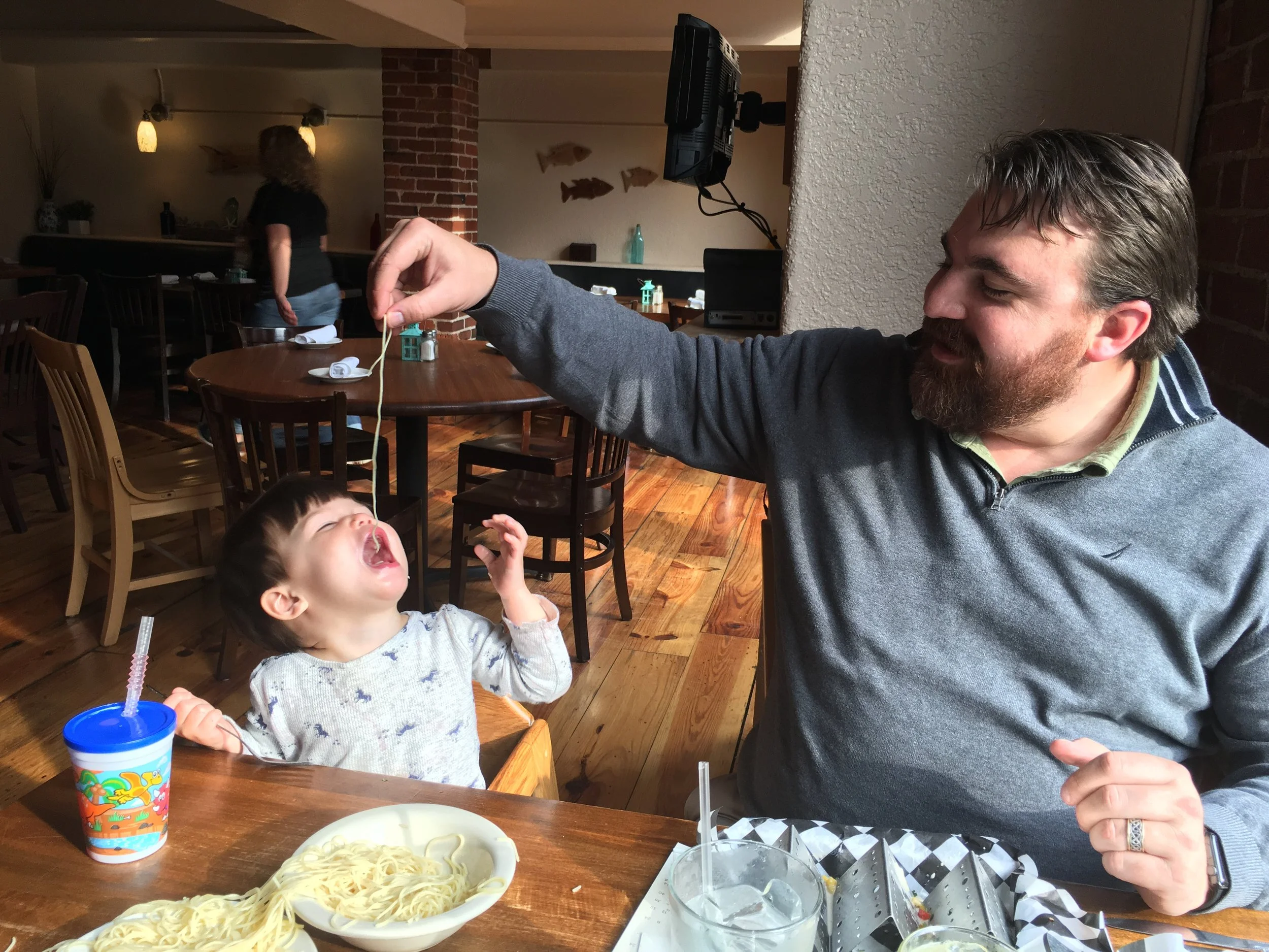 Closing here with a photo picturing half of our family enjoying a meal at the Carribean Smokehouse , one of our neighbors in the Brick Alley Building . We look forward to what we will create together and are enjoying each new neighbor we meet!