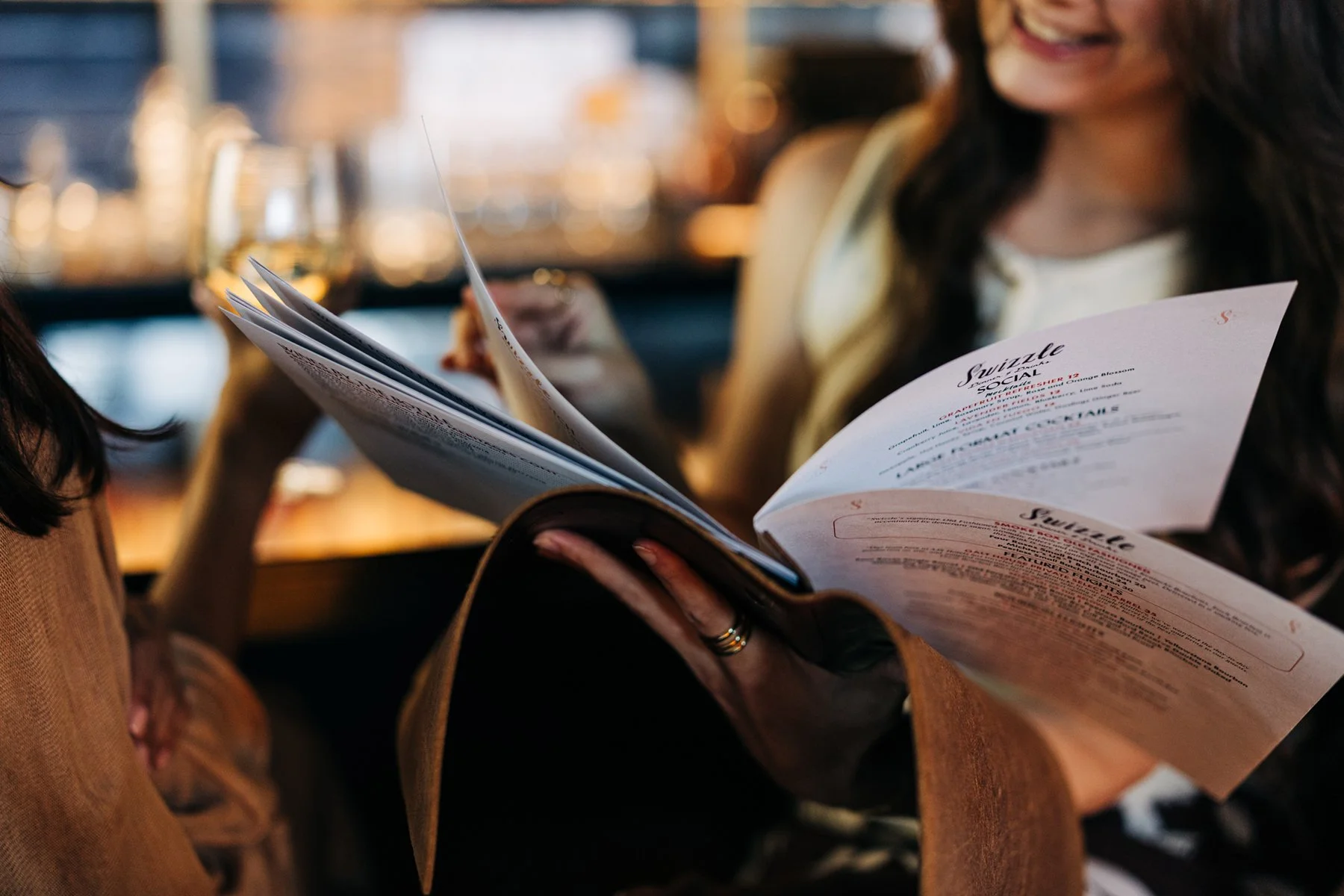  Woman flipping through a menu at Swizzle at the Galt House in Louisville, KY for a marketing campaign  