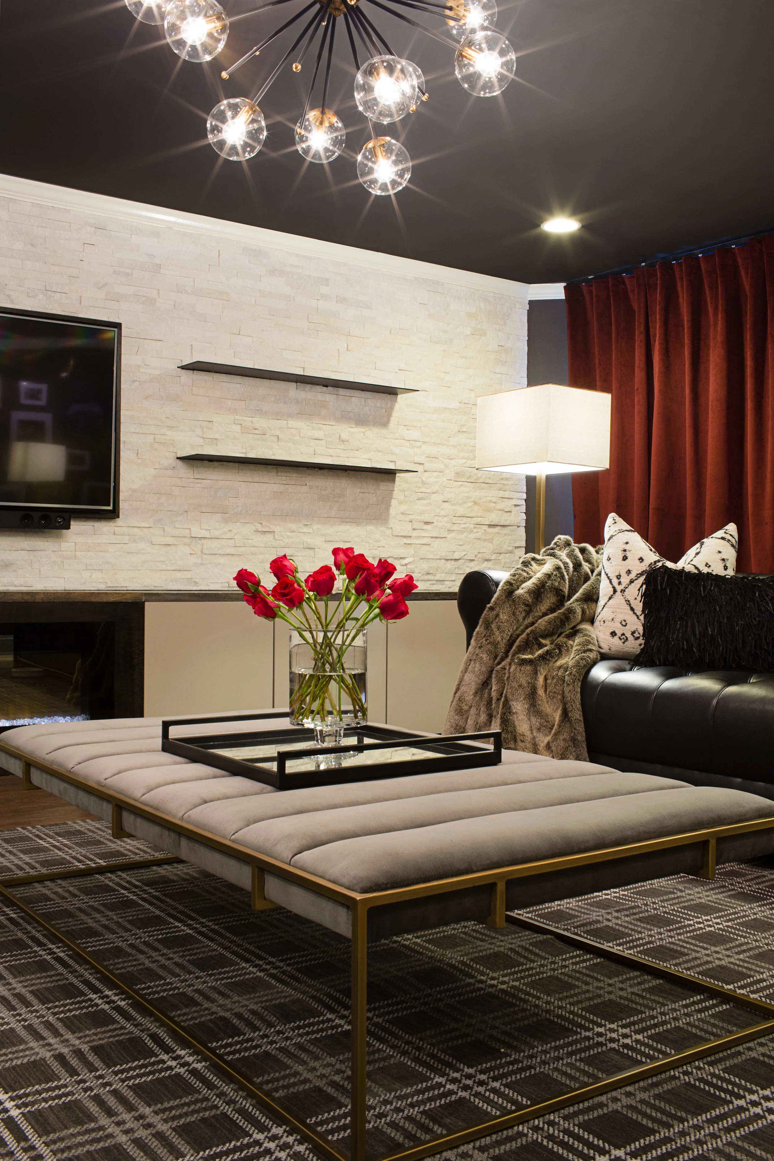 MUSIC LOVERS LOUNGE Soul, Hip-Hop, and Rock n' Roll. This music lovers lounge is moody, with sleek black leather Chesterfield sofas, a modern Plaid rug, wall-to-wall red velvet curtains, and warm brass metals. Steel shelves cantilever through a stone wall which introduces a natural element at the room's center.