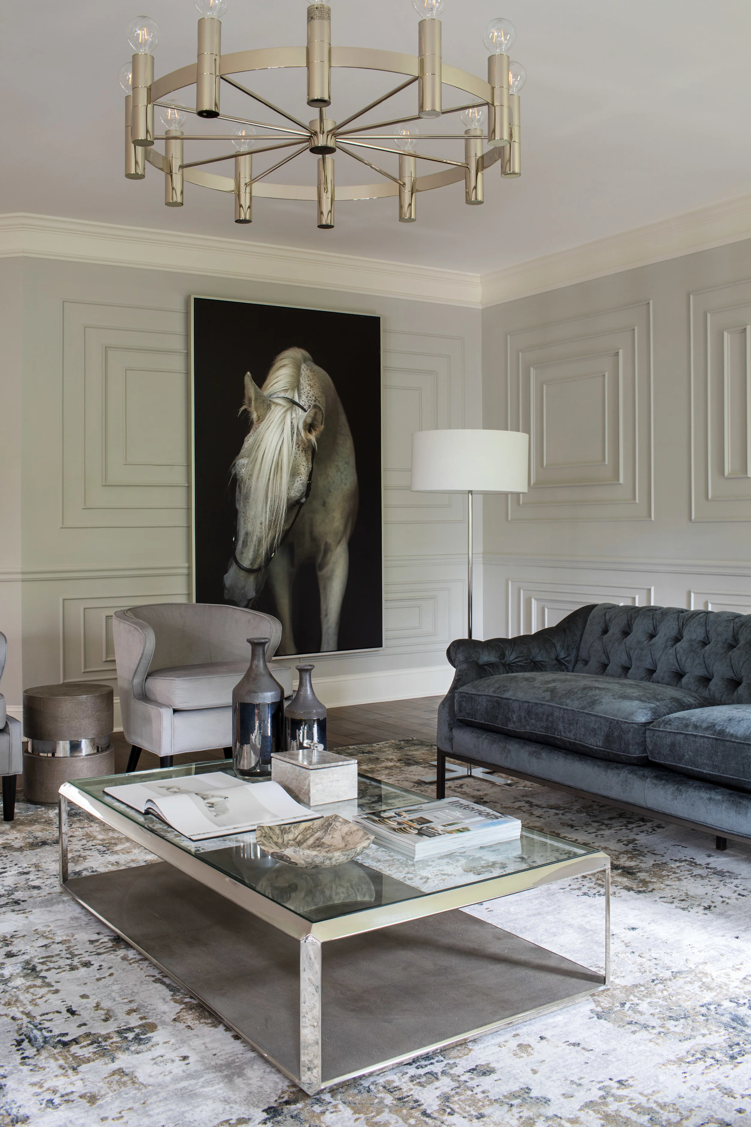 TRANSITIONAL LIVING Metal. Modern. Monochrome. This space highlights that it doesn’t take a lot of color to complete a room. The deep grays and soft whites create a canvas that allows the details in this space to shine; from the wainscoting, to the pops of gold throughout. The rich golds intertwined with the cool chromes showcase just how modern mixing metals can be.