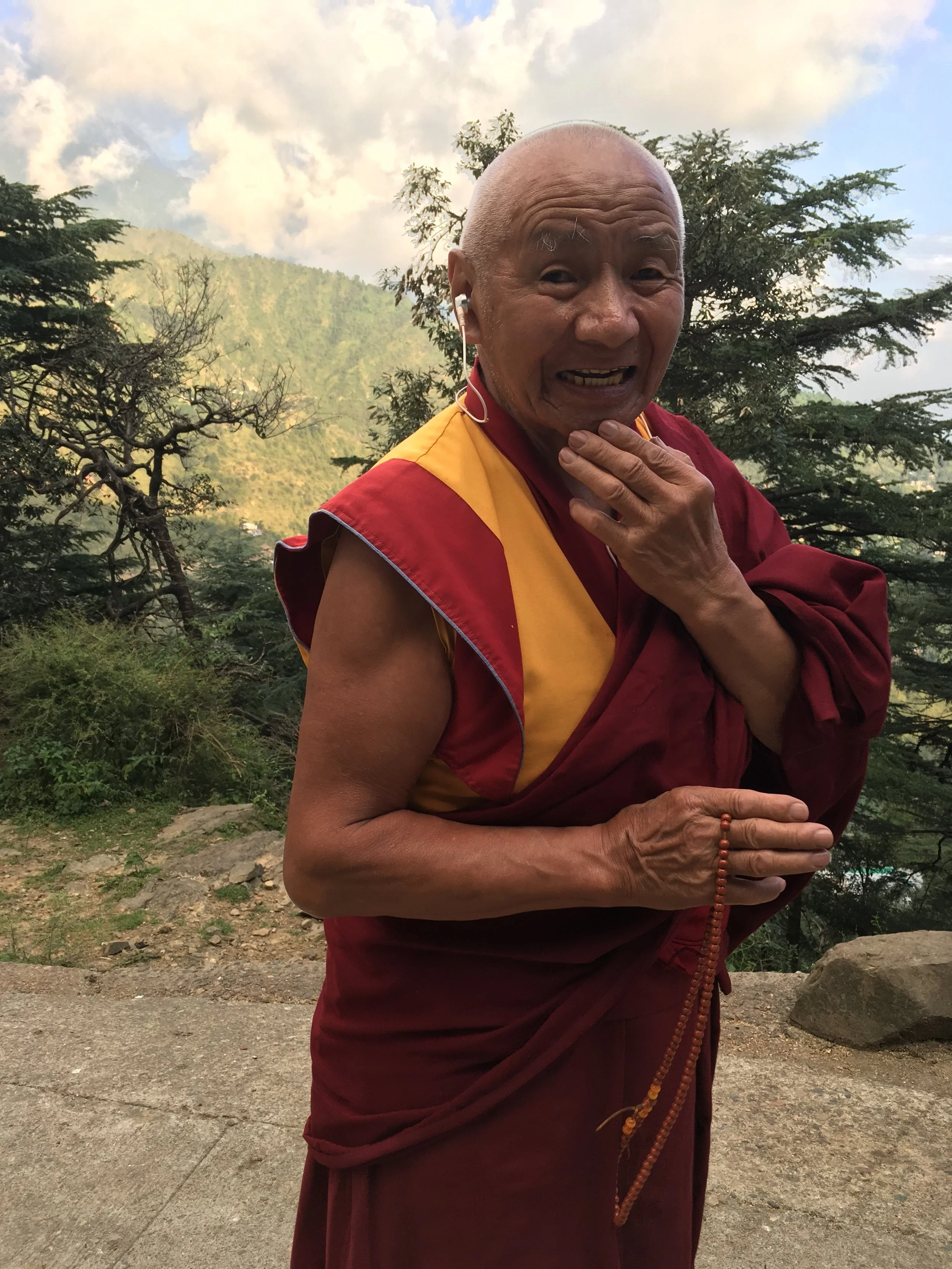 A monk pauses for a picture while on his meditation walk through a forested area near the Dalai Lama's temple in October 2018
