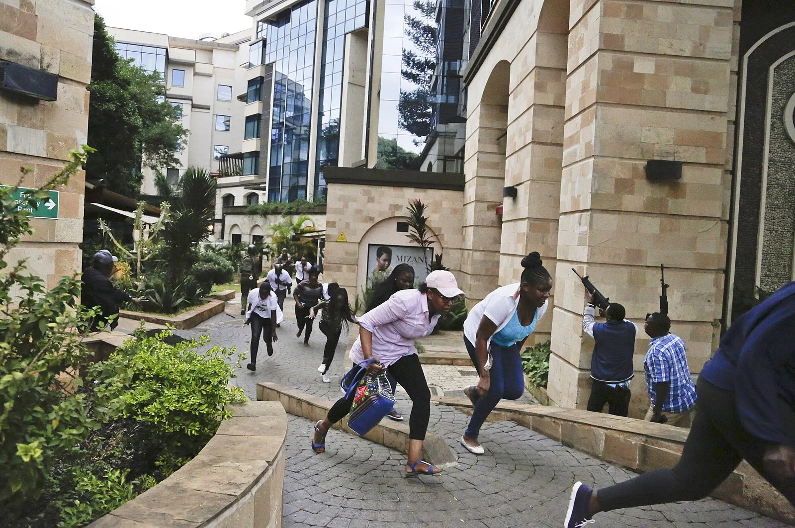 Guests flee a terrorist attack at the upscale Dusit hotel in Nairobi while plainclothes policemen enter the premises on Jan. 15, 2019. Photo by Shadrack Kimutai .