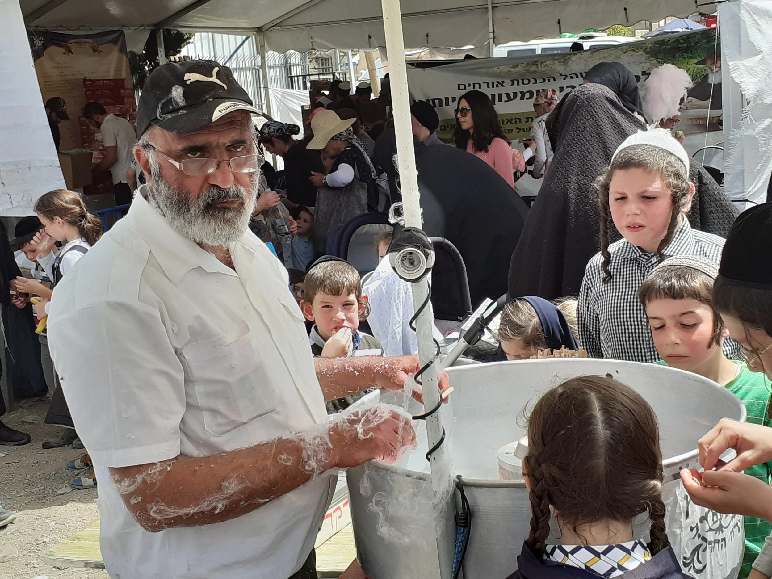Kids watch a candy floss-maker during Lag b’Omer. Photo by Gil Zohar.