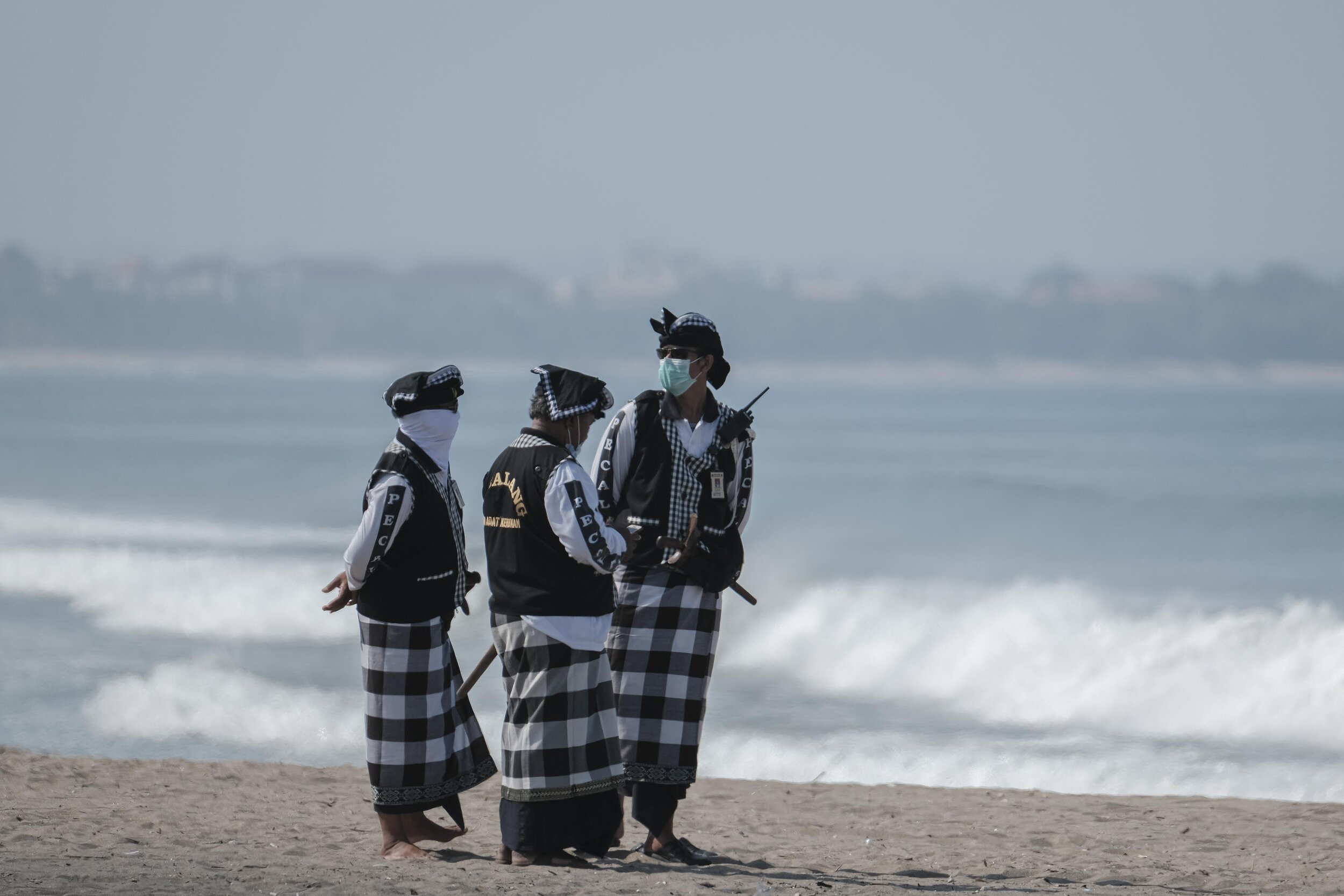  Local security officers, called Pecalang,&nbsp;stand guard to ensure the ceremony runs normally without disturbances from beach visitors. Photo By Agoes Rudianto. 