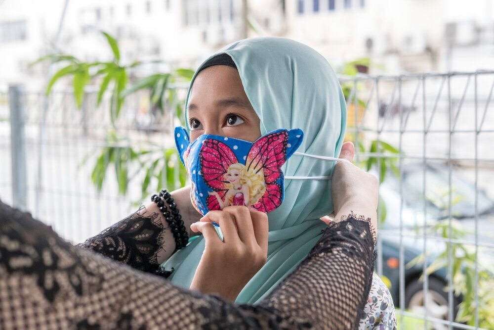  A child receives a face mask as a present on the first day of Eid al Fitr at a celebration organized by an NGO in Kuala Lumpur for employees that couldn’t return to their hometowns. “Usually we would give colorful envelopes with small amounts of mon