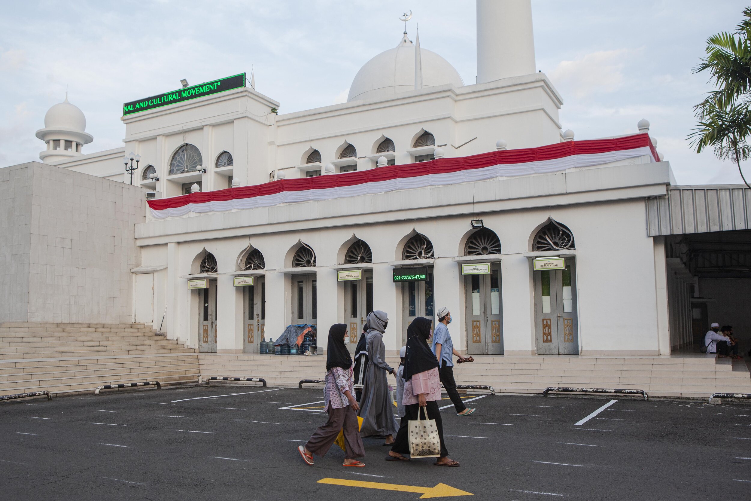  Muslims walk towards the fields in the Al Azhar Mosque complex in Jakarta. The mosque building was emptied and worship diverted outdoors. Photo by Agoes Rudianto. 