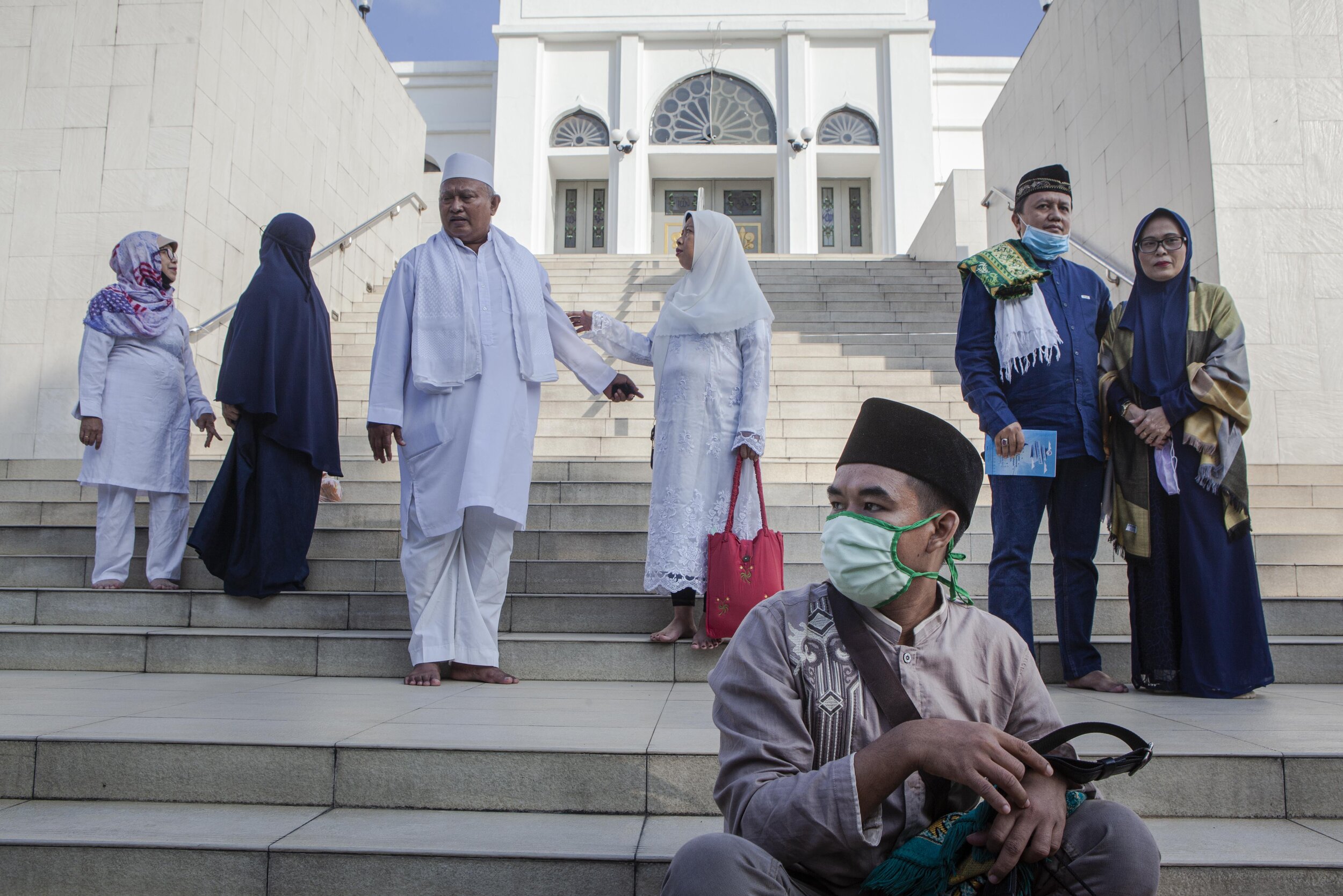  People pose as they take pictures with their families after the Eid al-Adha prayer. This celebration is an opportunity for families to stay in touch and spend time together. Photo by Agoes Rudianto. 