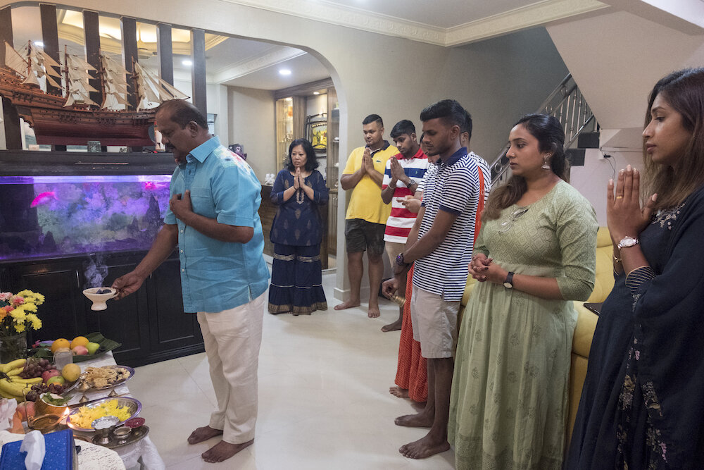  Dato’ Mahalingam prays together with his family in their house in Kuala Lumpur on the Diwali eve. Prayers and offerings were given to the ancestors before starting the Diwali celebration. Photo by Alexandra Radu. 