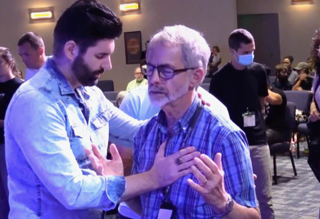 Evangelist Charlie Shamp (left) prays for Keith Webb, executive pastor of Seattle Revival Center in Newcastle, Wash. Photo by Julia Duin.