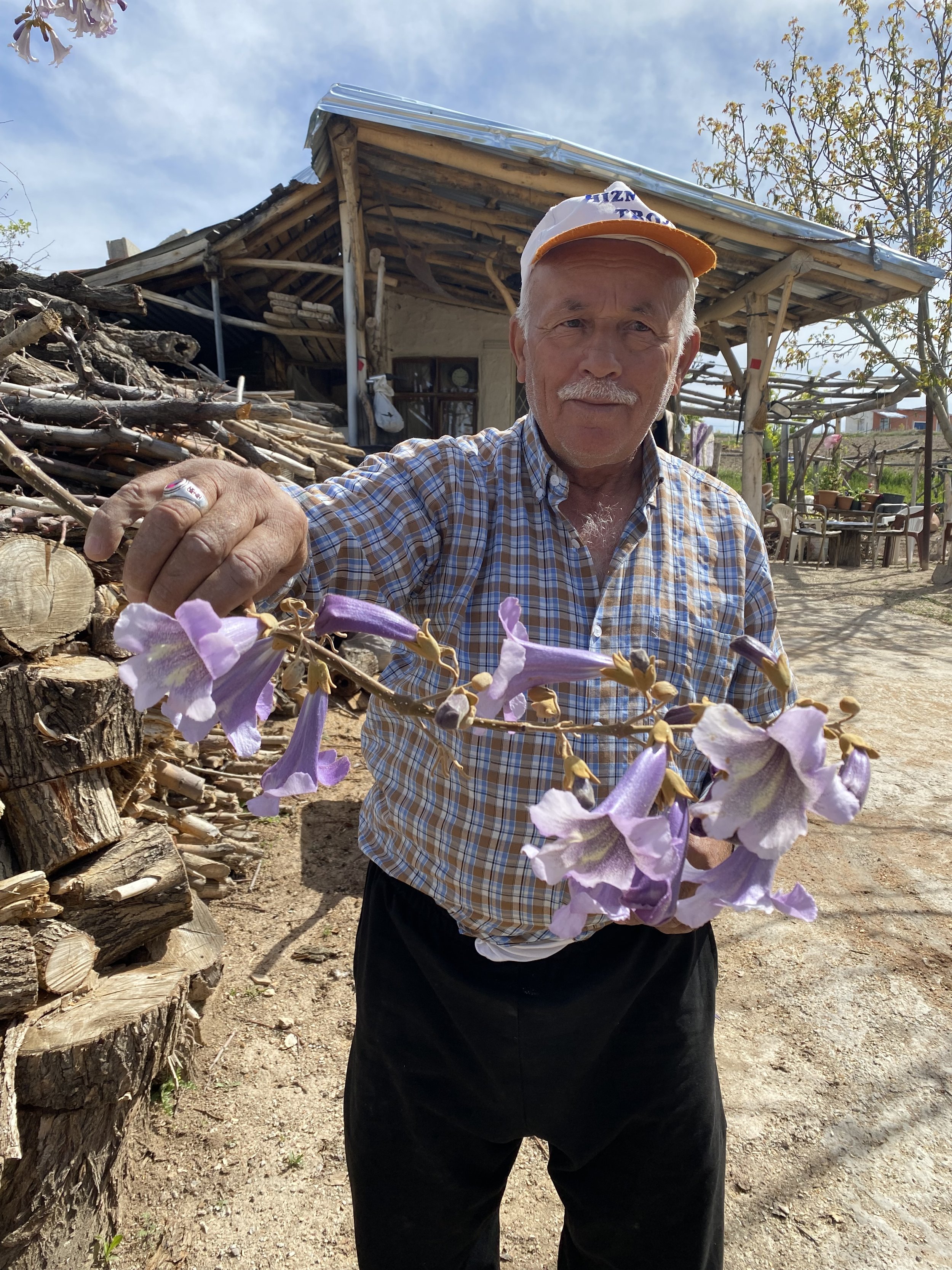 A farmer shows off the blooms in his farm across from the archeological tell, or mound, over the biblical town of Lystra.