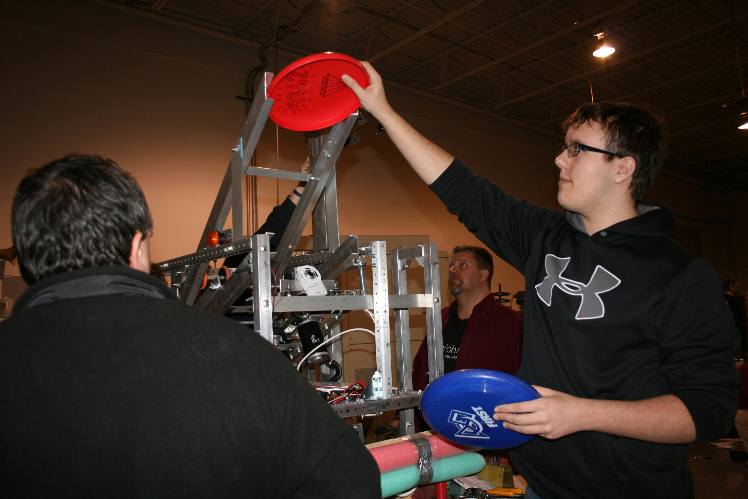 student loads frisbee into machine