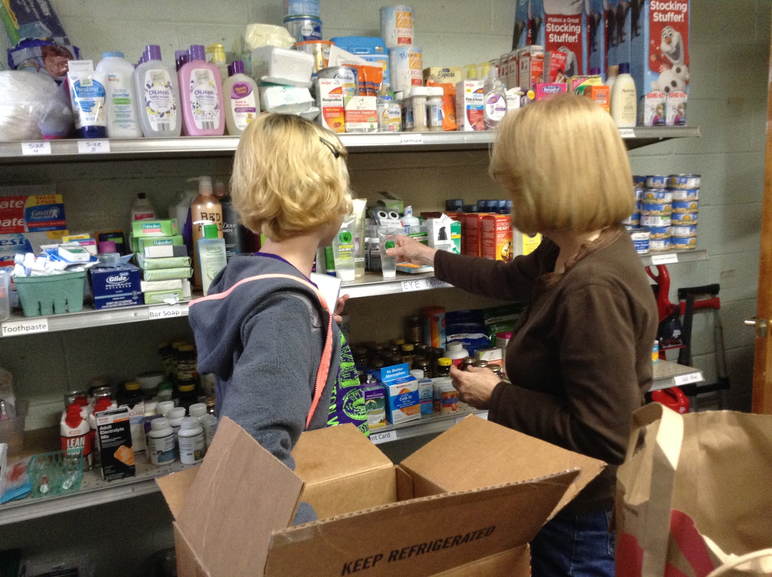 people next to shelves of hygiene items