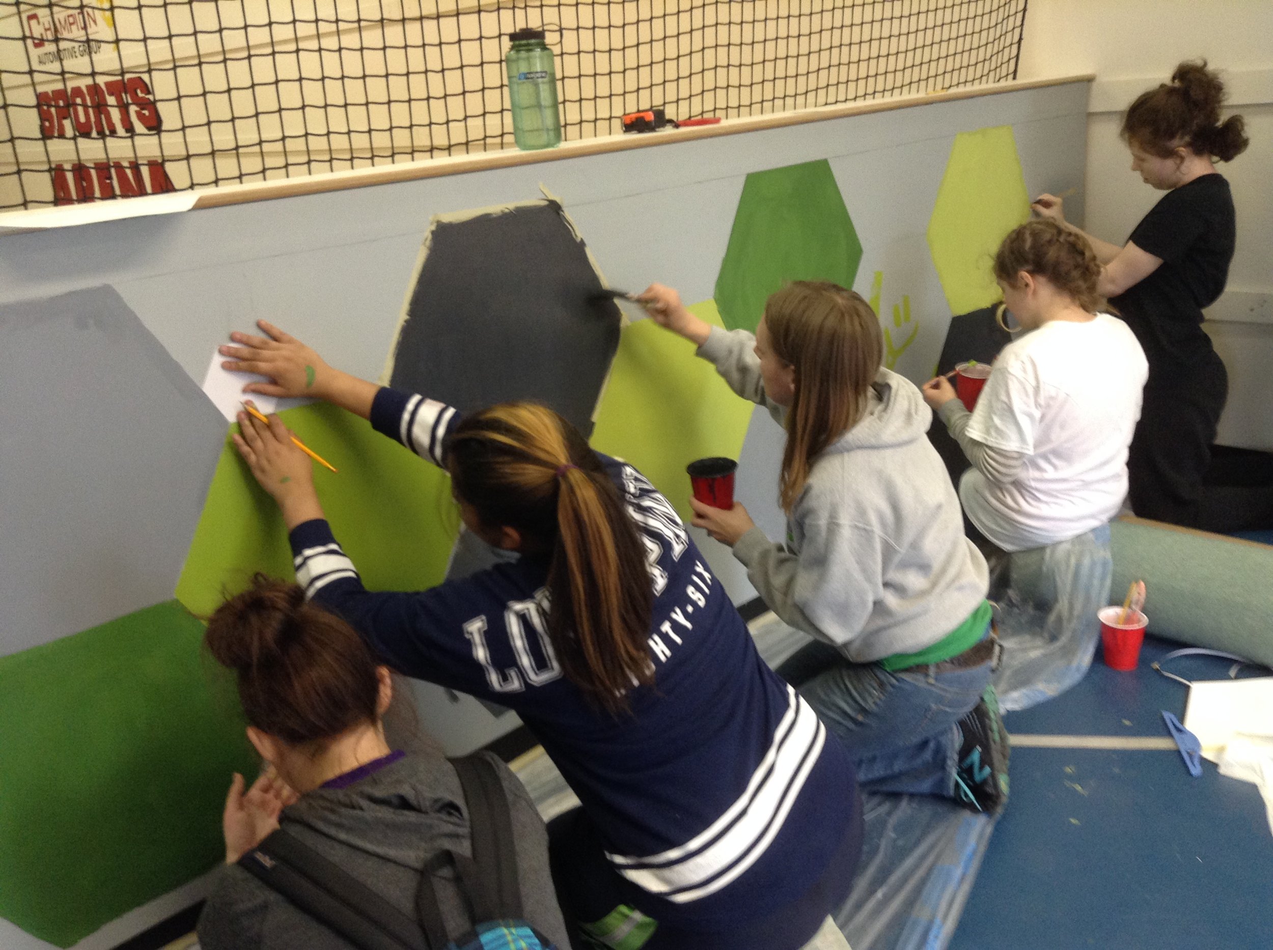 group of students painting a wall