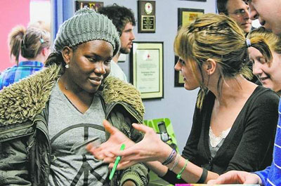 Invisible Children representative Achiro Fionah, left, listens to Kensington Woods High School senior Kyra Gregor for the school's project on the Invisible Children program, which raises awareness of child soldiers exploited for the ongoing conflict in Northern Uganda. / SUBMITTED PHOTO