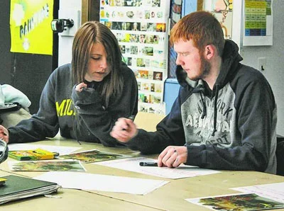 Sophomores Keely Madson and Chris Talbot discuss artwork by contemporary artist Yinka Shonebare titled "Scramble for Africa." Students looked at issues in African history to put the Ugandan situation into context before viewing Invisible Children films. / SUBMITTED PHOTO