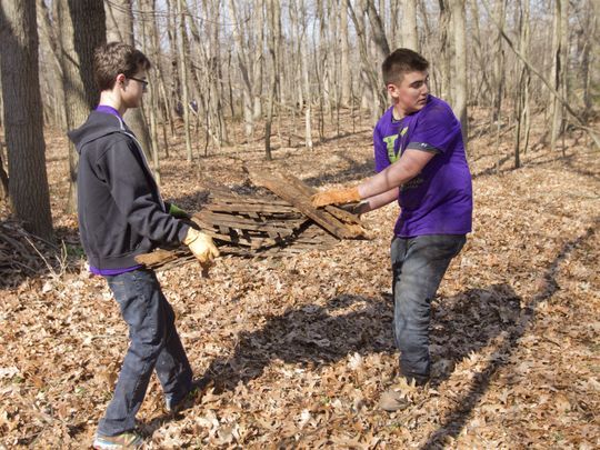 Kensington Woods 10th grader Isaac Provencher, left, and seventh grader Nathan Picano clear wood debris from the woods of Strawberry Point Nature Preserve in Hamburg Township as part of the school's day of service. (Photo: Gillis Benedict/Livingston Daily)