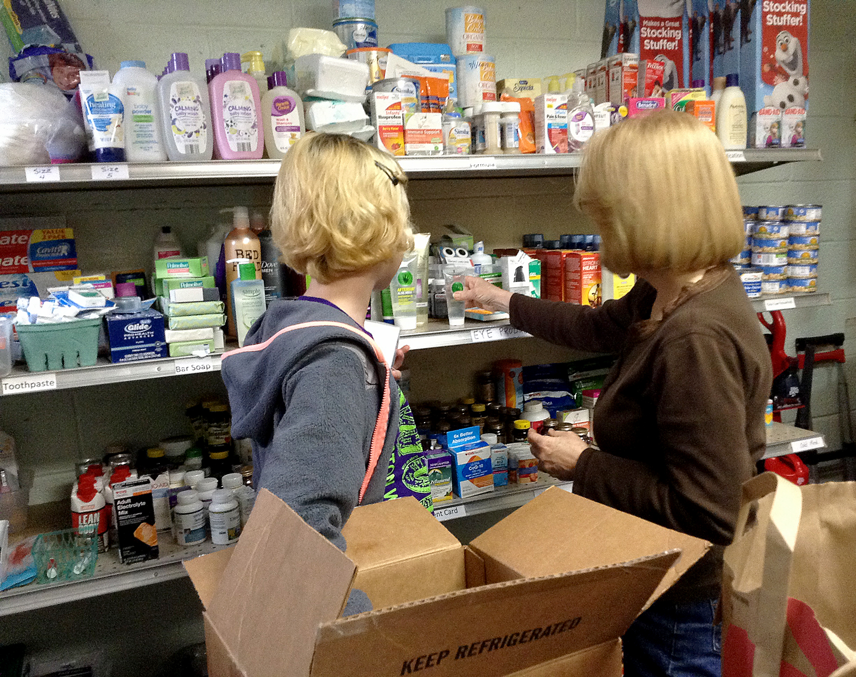 students stocking shelves with hygiene items