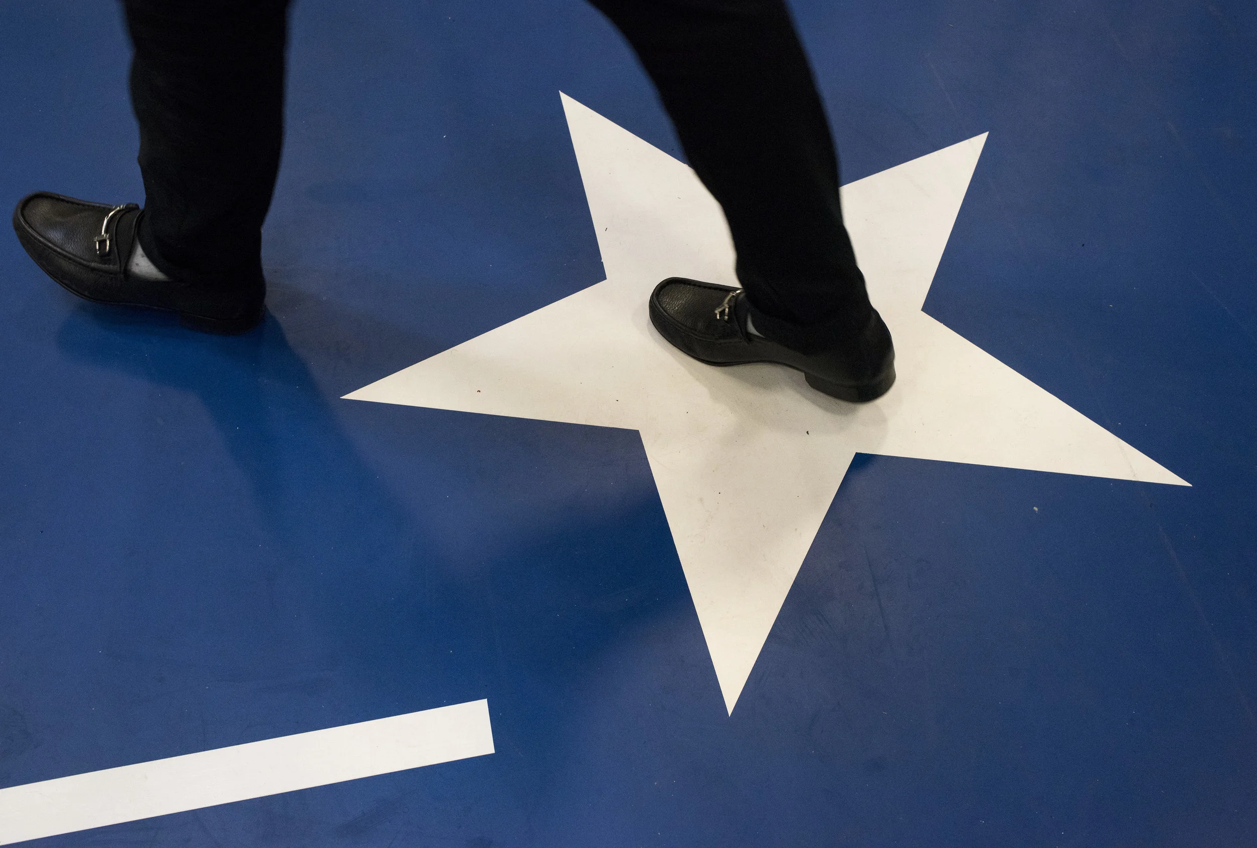 People walk across a star painted on the floor as they find their way into the crowd before the start of a Hillary Clinton campaign event on October 21, 2016 in Cleveland, Ohio, U.S.