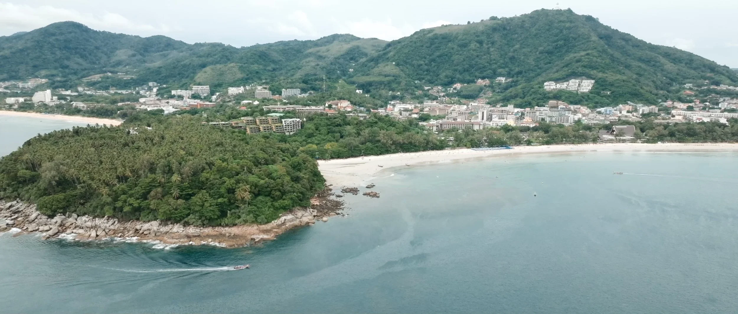 Drone shot of Patong Beach in Phuket, Thailand, showing the coastline and lush greenery