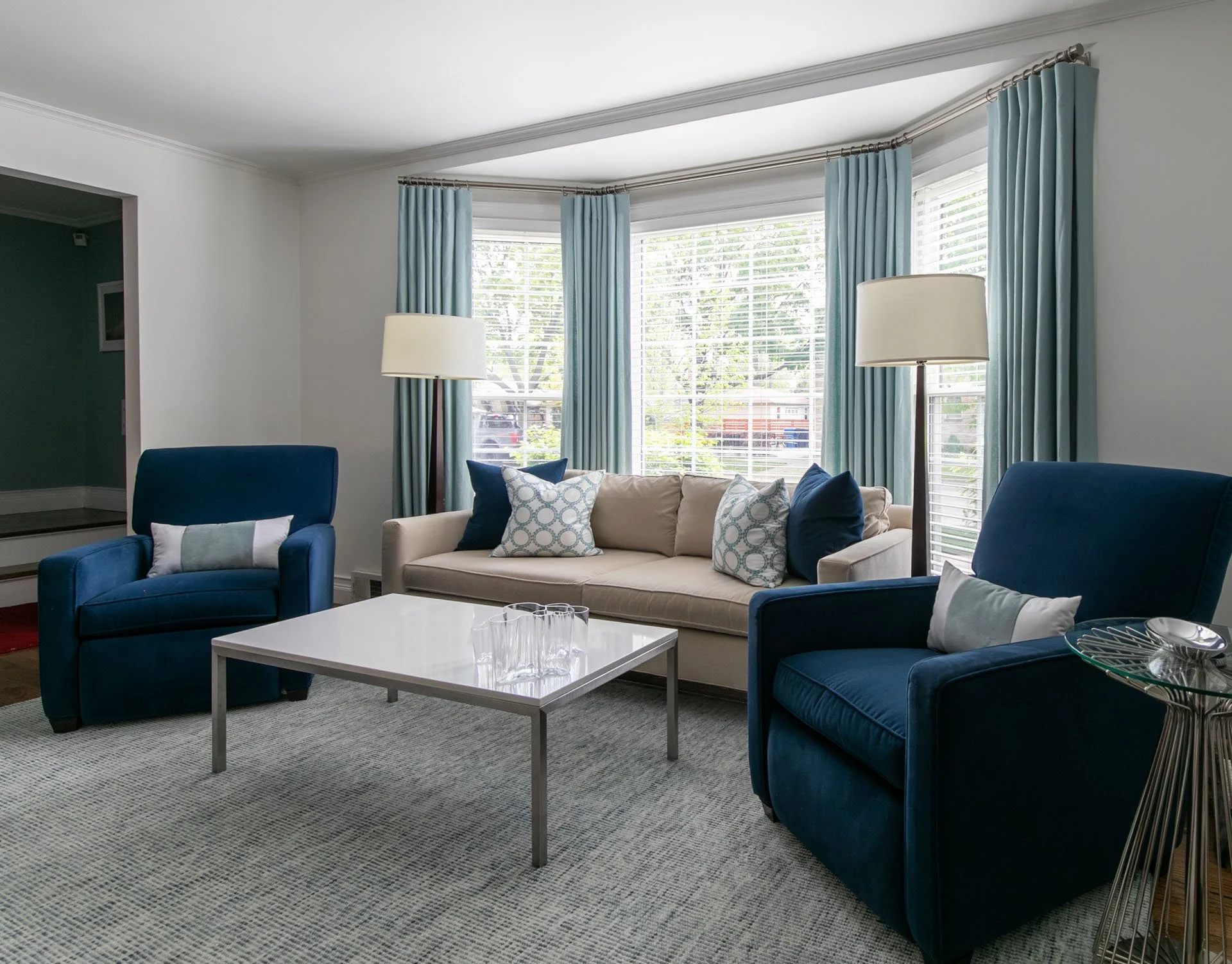 Edgebrook, Chicago, IL living room with bay window, blue drapery, beige sofa, and navy recliners designed by Wendy Nobriga Interiors