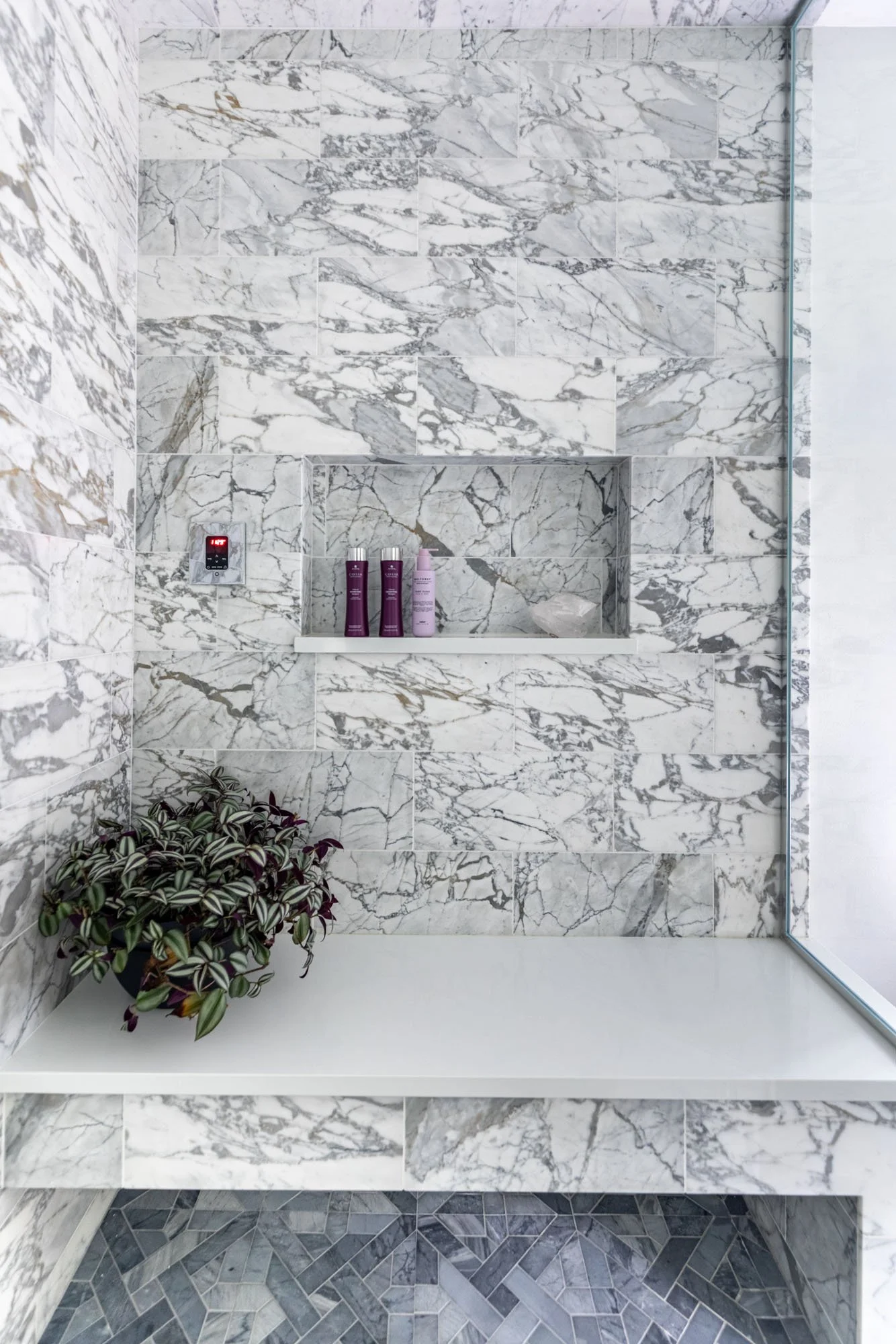 Marble shower niche in a primary bathroom in Northbrook, Illinois. Design by Wendy Nobriga Interiors.
