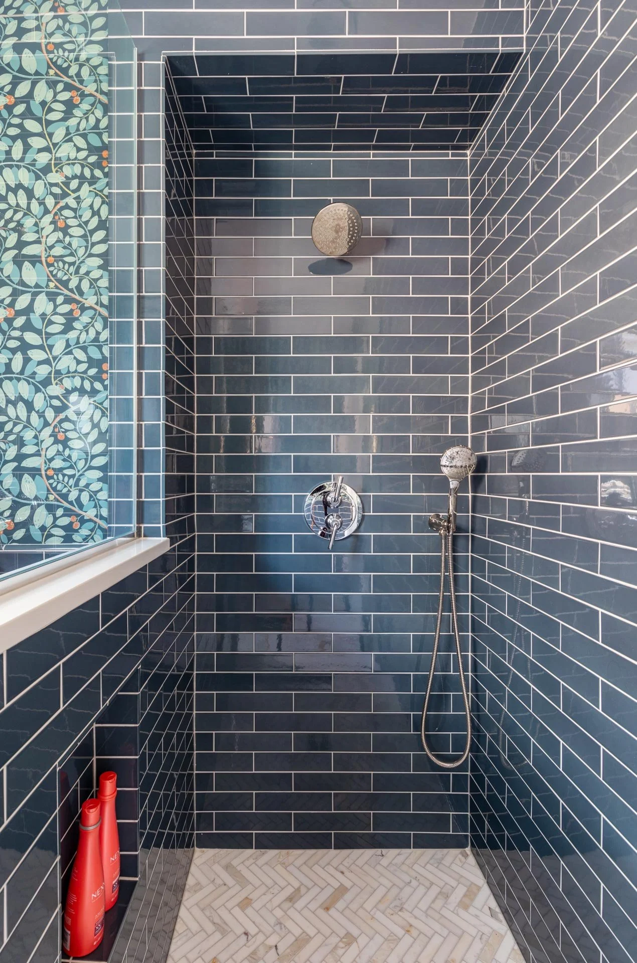 Lake Forest IL bathroom with navy subway tile shower, polished nickel
fixtures, and herringbone marble floor designed by Wendy Nobriga Interiors.
