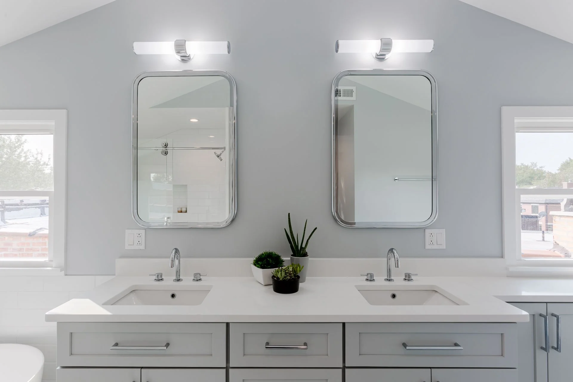 North Center Chicago bathroom with double vanity, chrome fixtures, frameless mirrors, and gray walls, designed by Wendy Nobriga Interiors