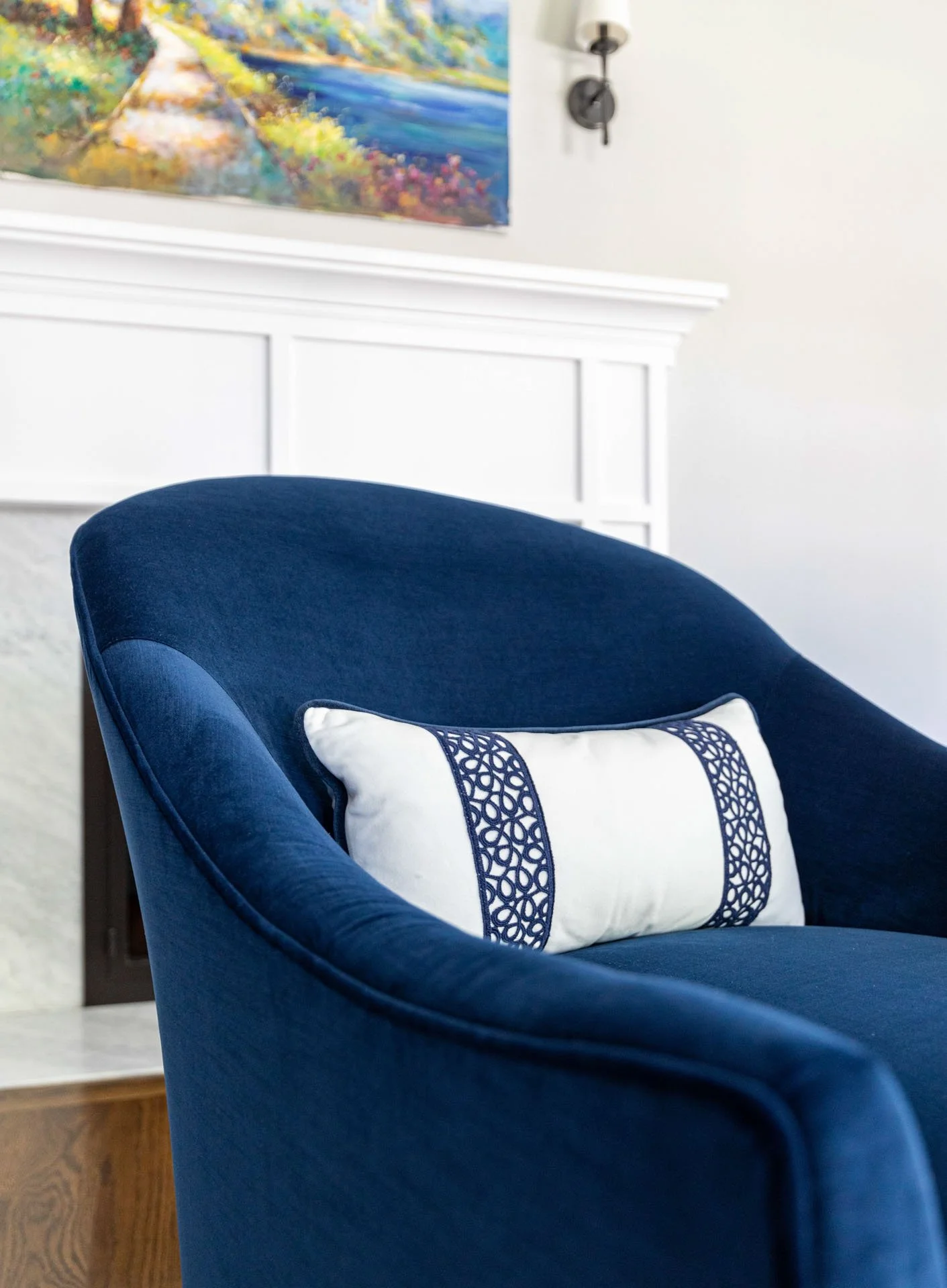 La Grange IL living room detail of navy chair with white embroidered pillow in front of fireplace designed by Wendy Nobriga Interiors