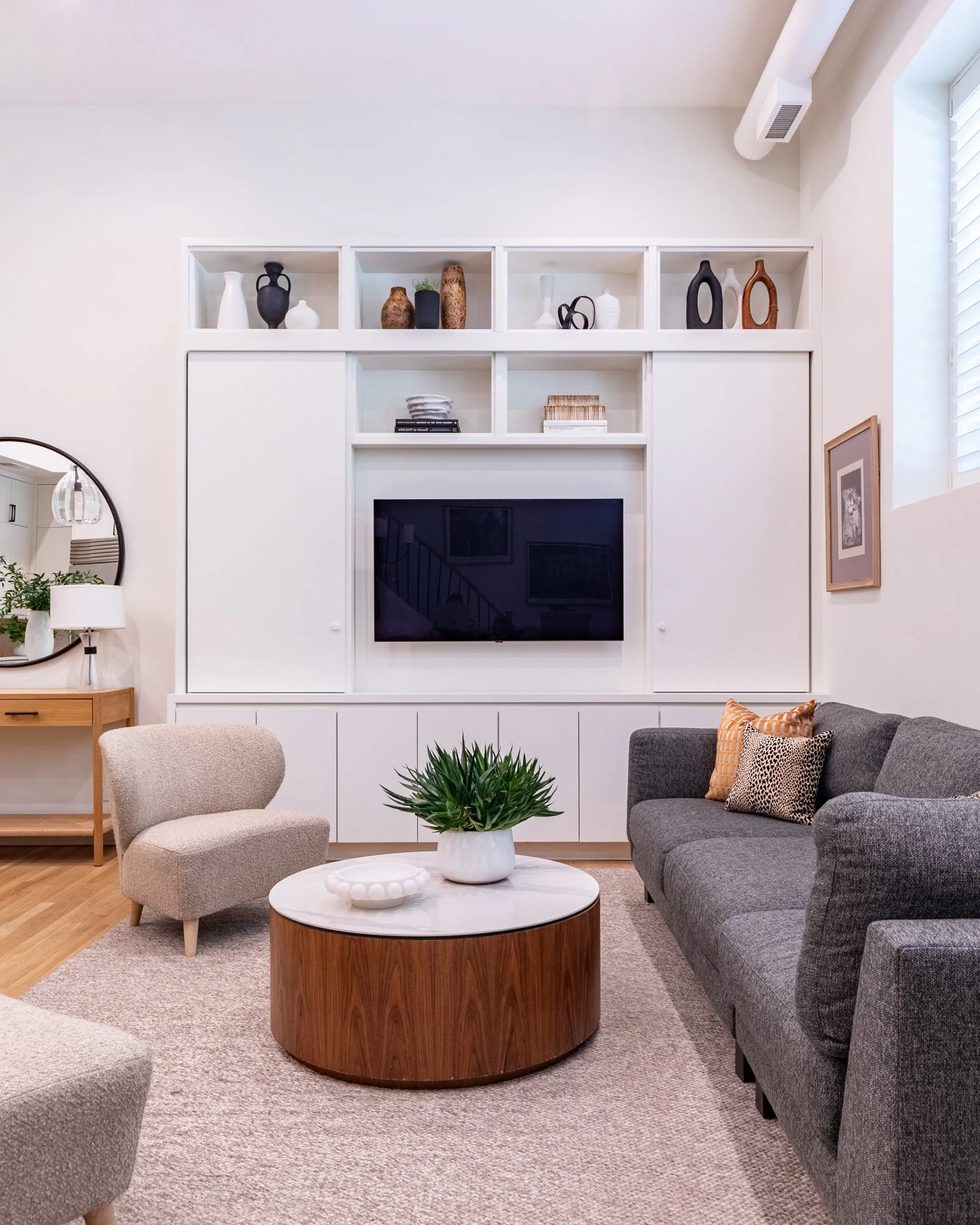 Lincoln Park, Chicago modern media wall designed by Wendy Nobriga Interiors with concealed doors that slide open to reveal the television while maintaining a clean, streamlined appearance.