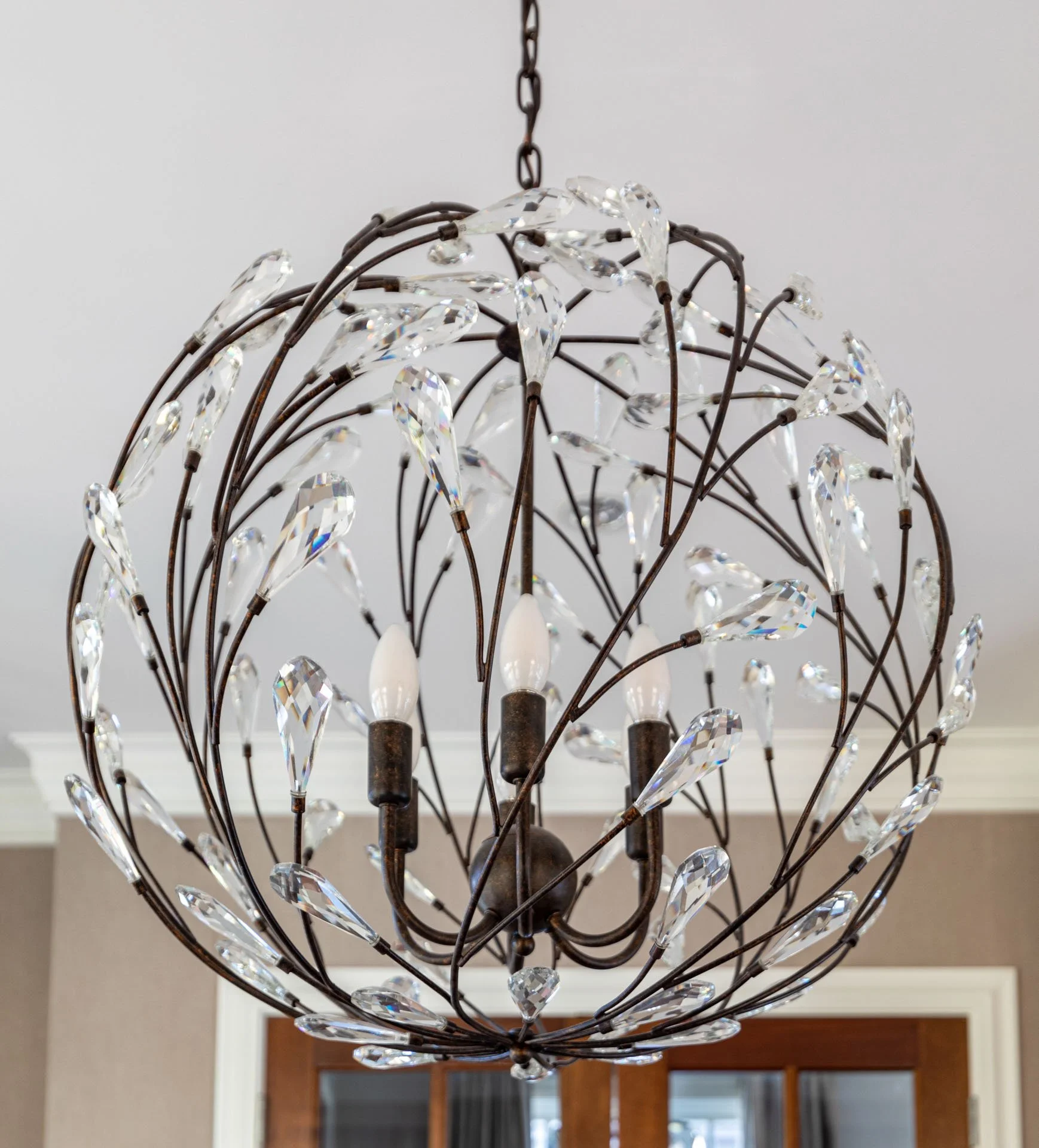 Close-up of crystal orb chandelier with bronze frame in Roscoe Village Chicago home office, designed by Wendy Nobriga Interiors.