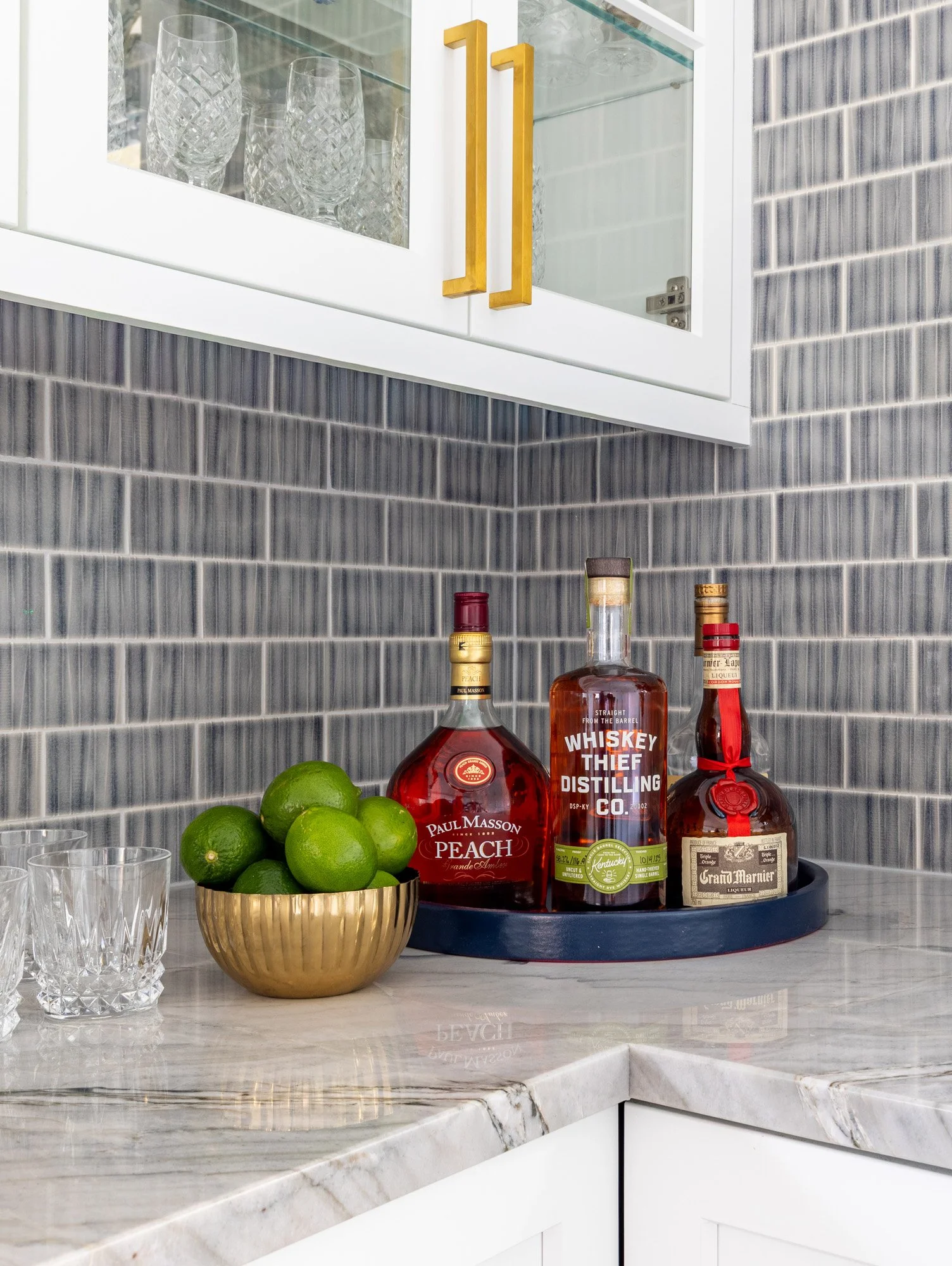 North Edgebrook Chicago quartzite countertop detail with brass hardware, textured blue tile backsplash, and a custom beverage station, designed by Wendy Nobriga Interiors.