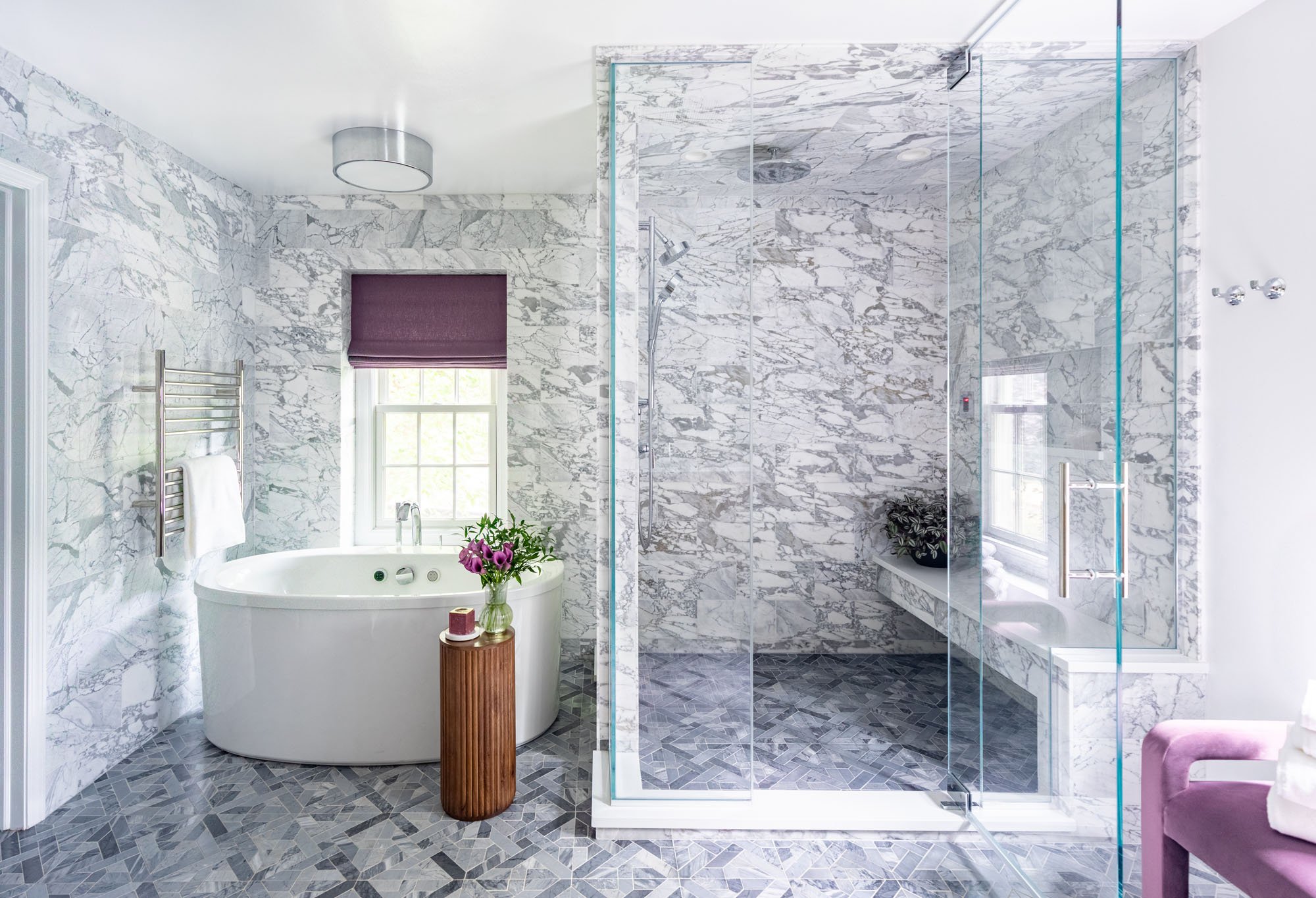 Primary bathroom in Northbrook, Illinois with marble shower, freestanding tub, and custom glass enclosure. Design by Wendy Nobriga Interiors.