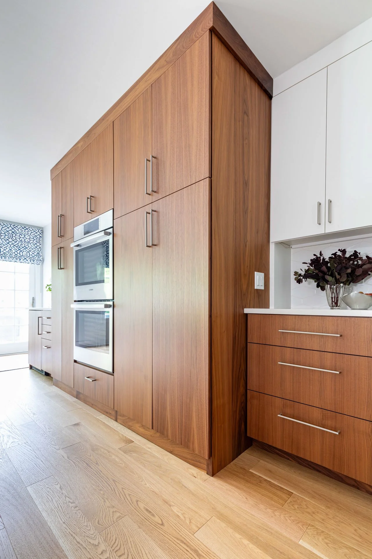 Wildwood Chicago IL kitchen with tall wood pantry wall, double ovens, and modern cabinetry details, designed by Wendy Nobriga Interiors.